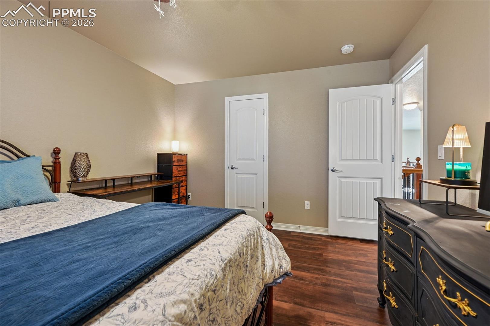 Bedroom featuring dark wood-type flooring and baseboards