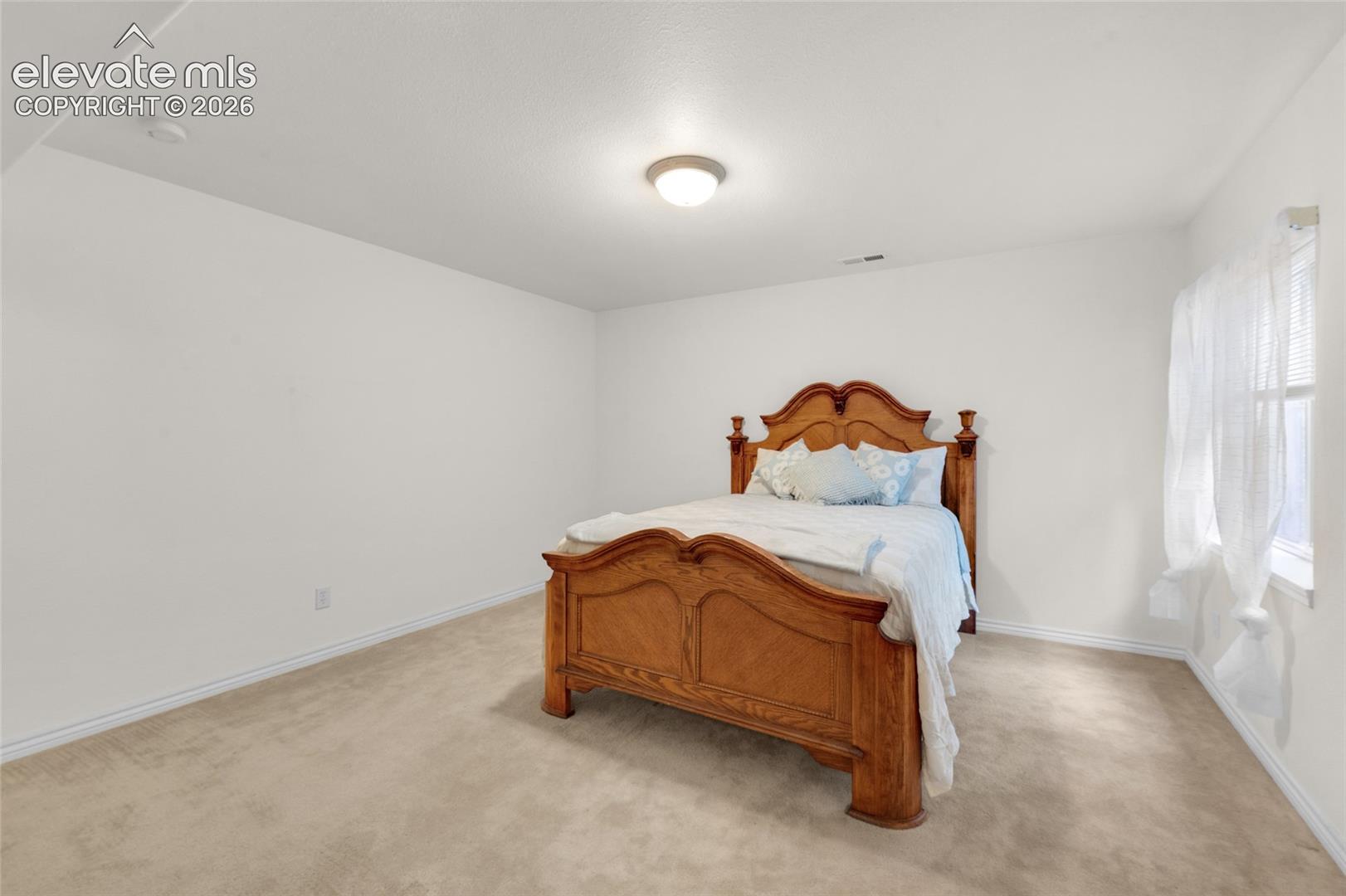 Neutral wall-to-wall carpeting, crisp white interior paint, and a central dome-style ceiling light fixture