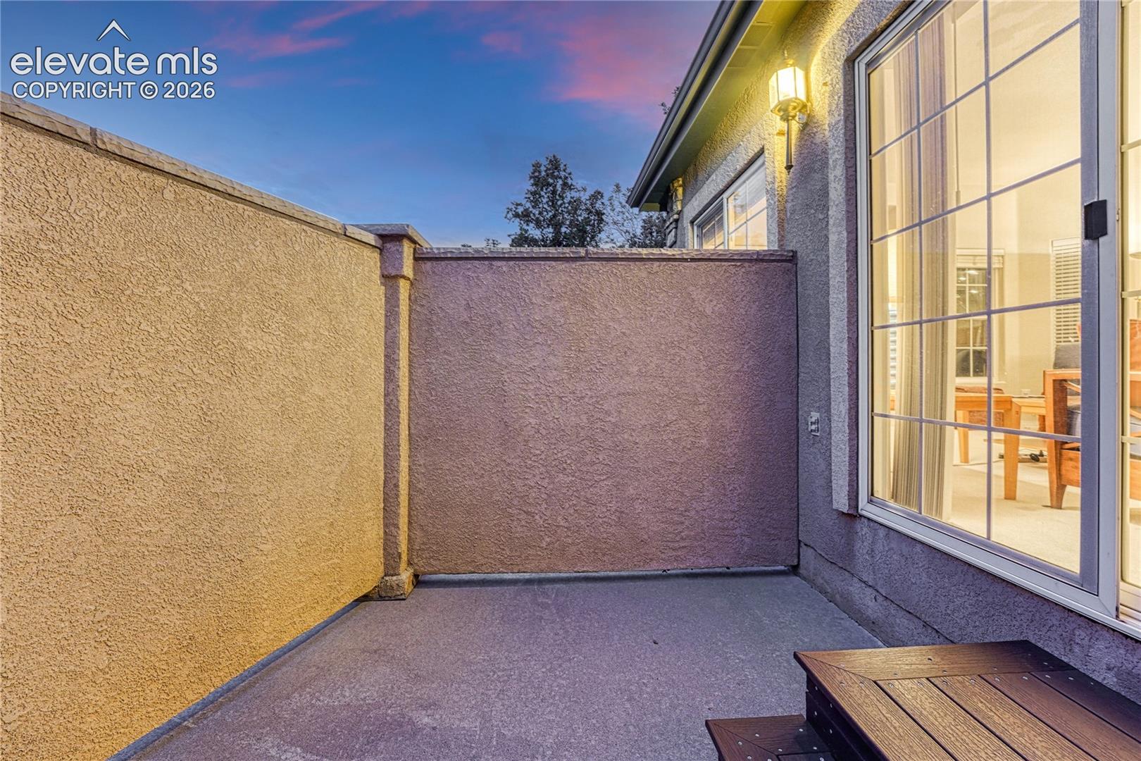 Enjoy evening relaxation on the enclosed patio with exterior lighting and solid stucco privacy walls
