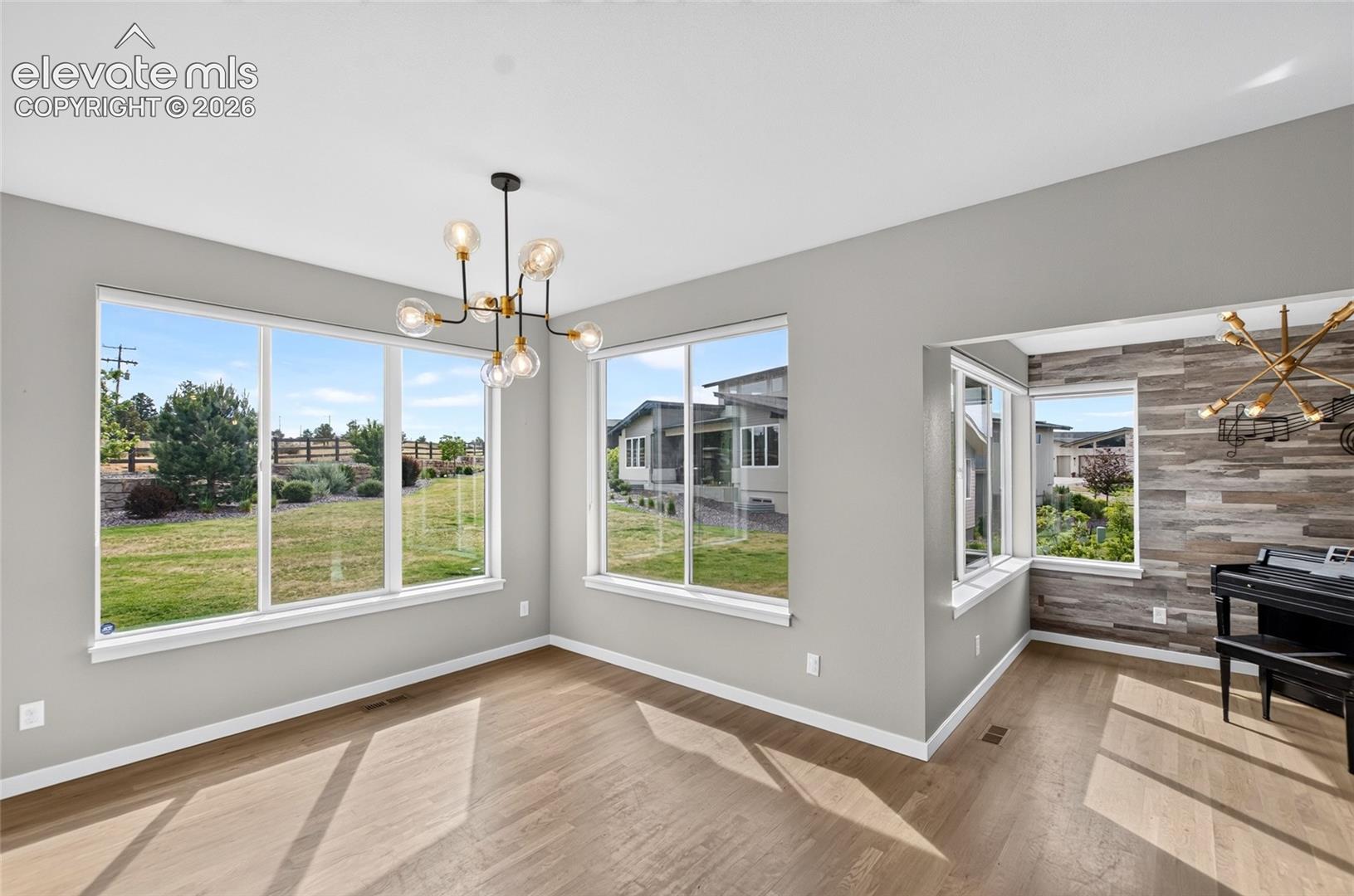 Spacious interior room featuring wood-finish flooring and light gray walls