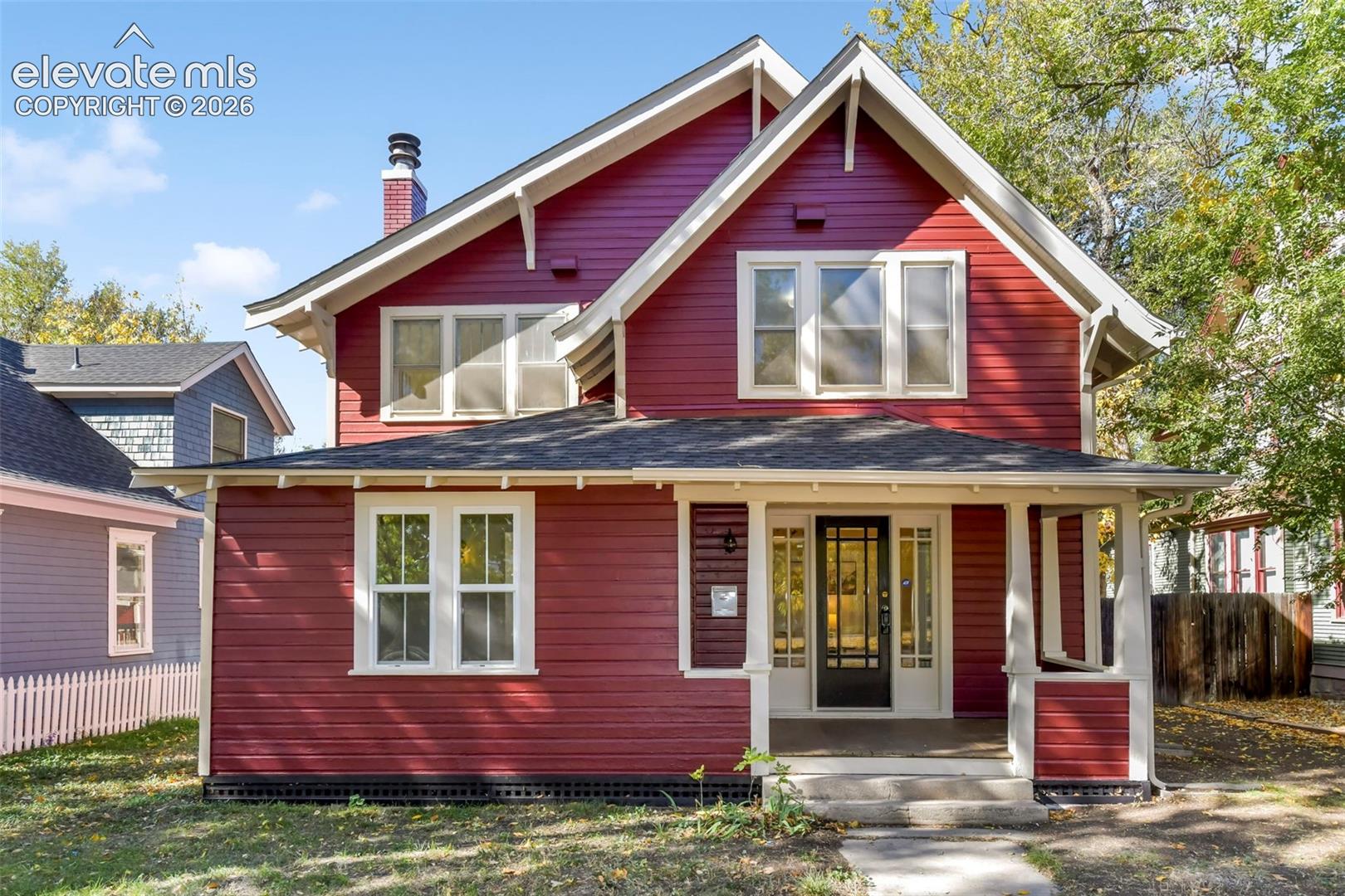 Craftsman-style exterior featuring horizontal siding, a covered front porch with square columns, a multi-gabled roofline, and a chimney with brick detailing