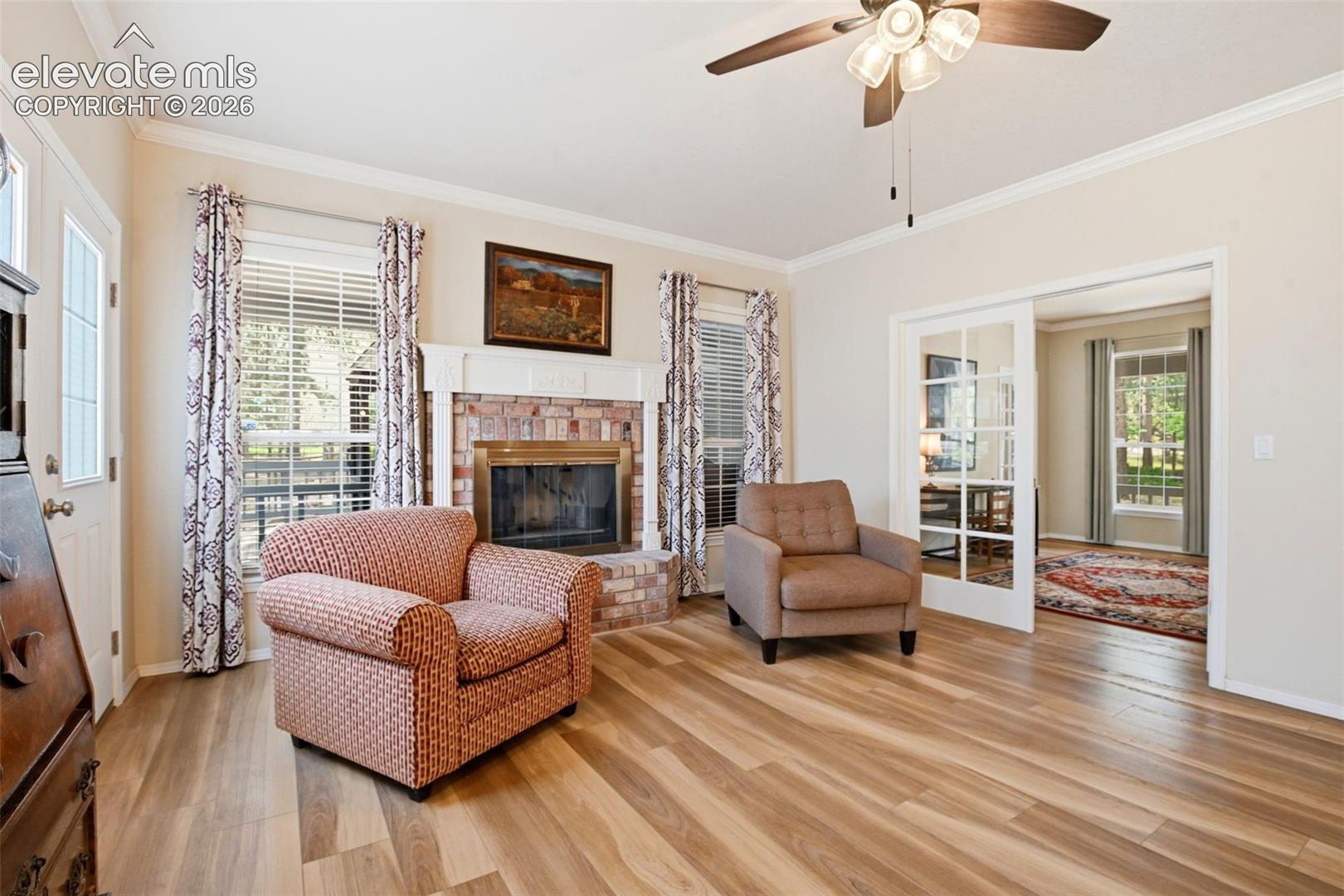 Great room with gas log fireplace and brick surround leads to the office and out to the deck.
