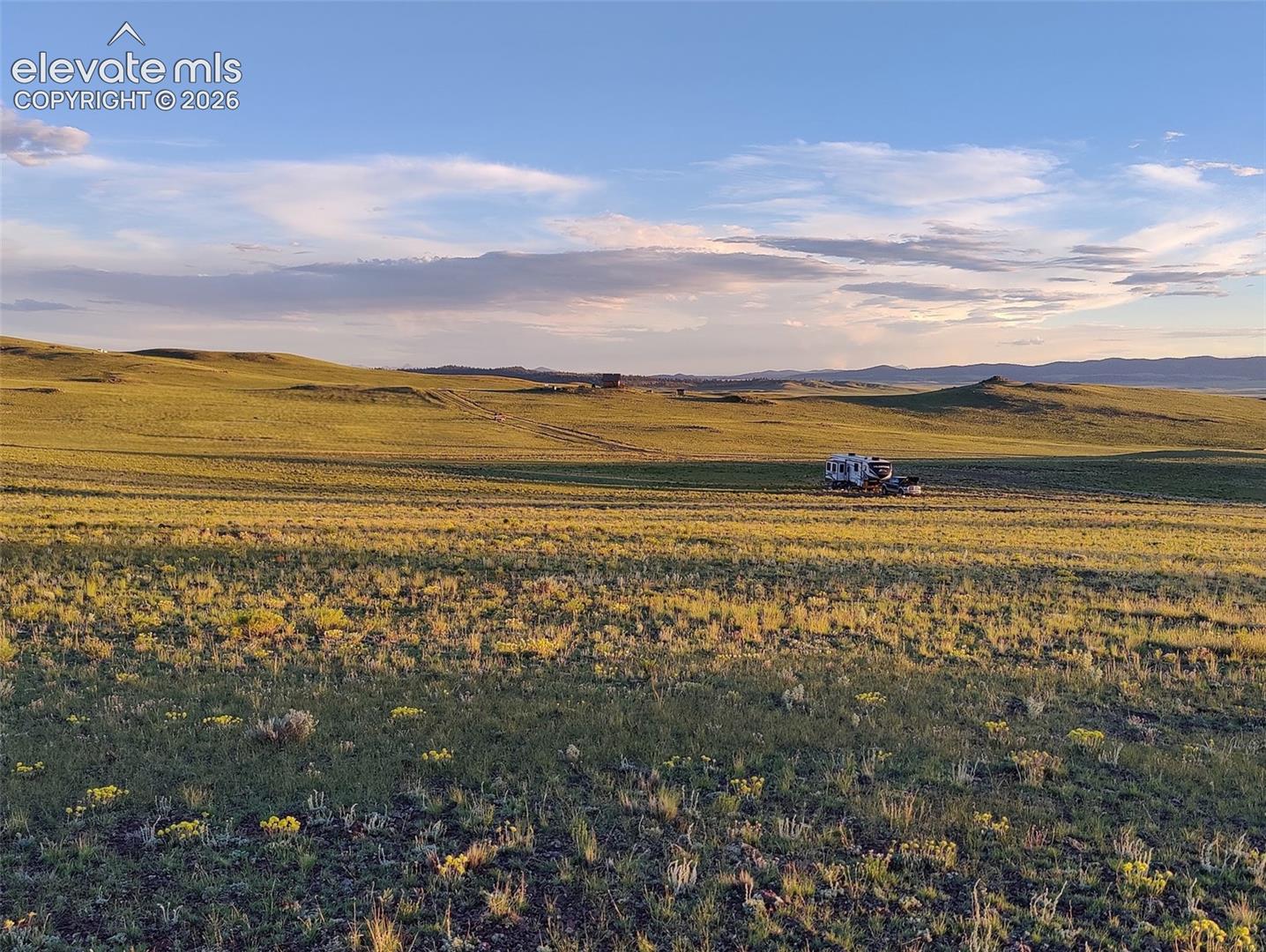 Expansive acreage featuring rolling terrain, native grasses, and distant mountain topography
