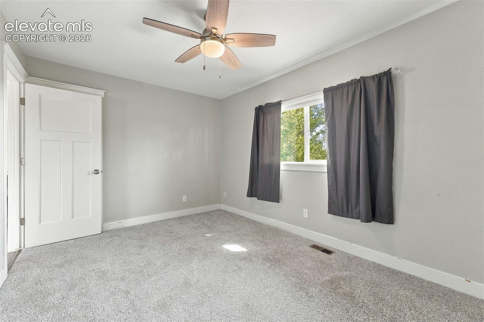 Plush carpeting, a ceiling fan with integrated lighting, and white trim work