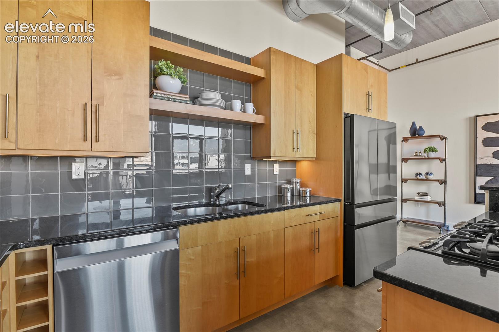 Updated stainless appliances and luxurious glass tile backsplash