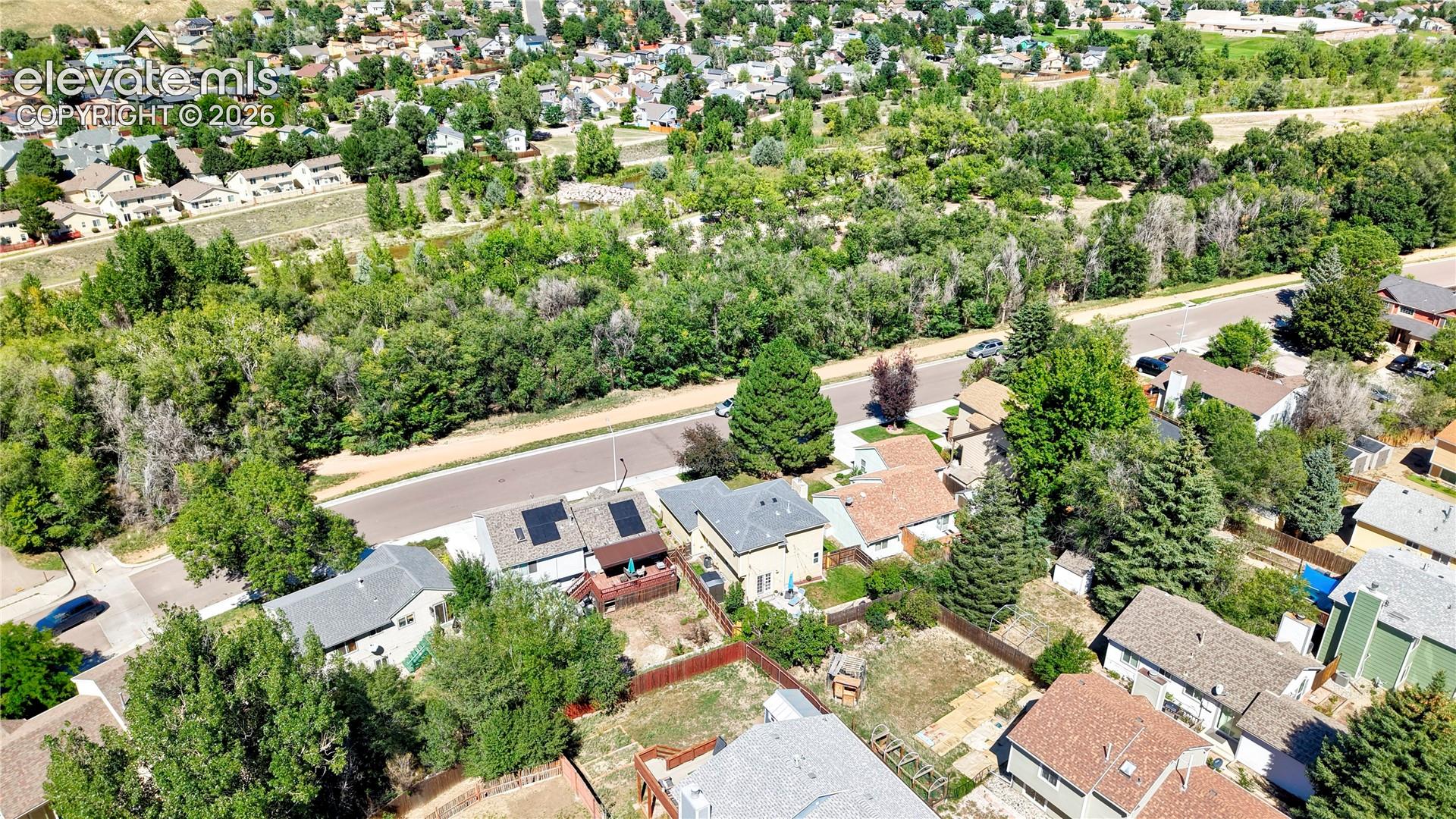 Aerial View of the back of the home across from trail and Cottonwood Creek Park