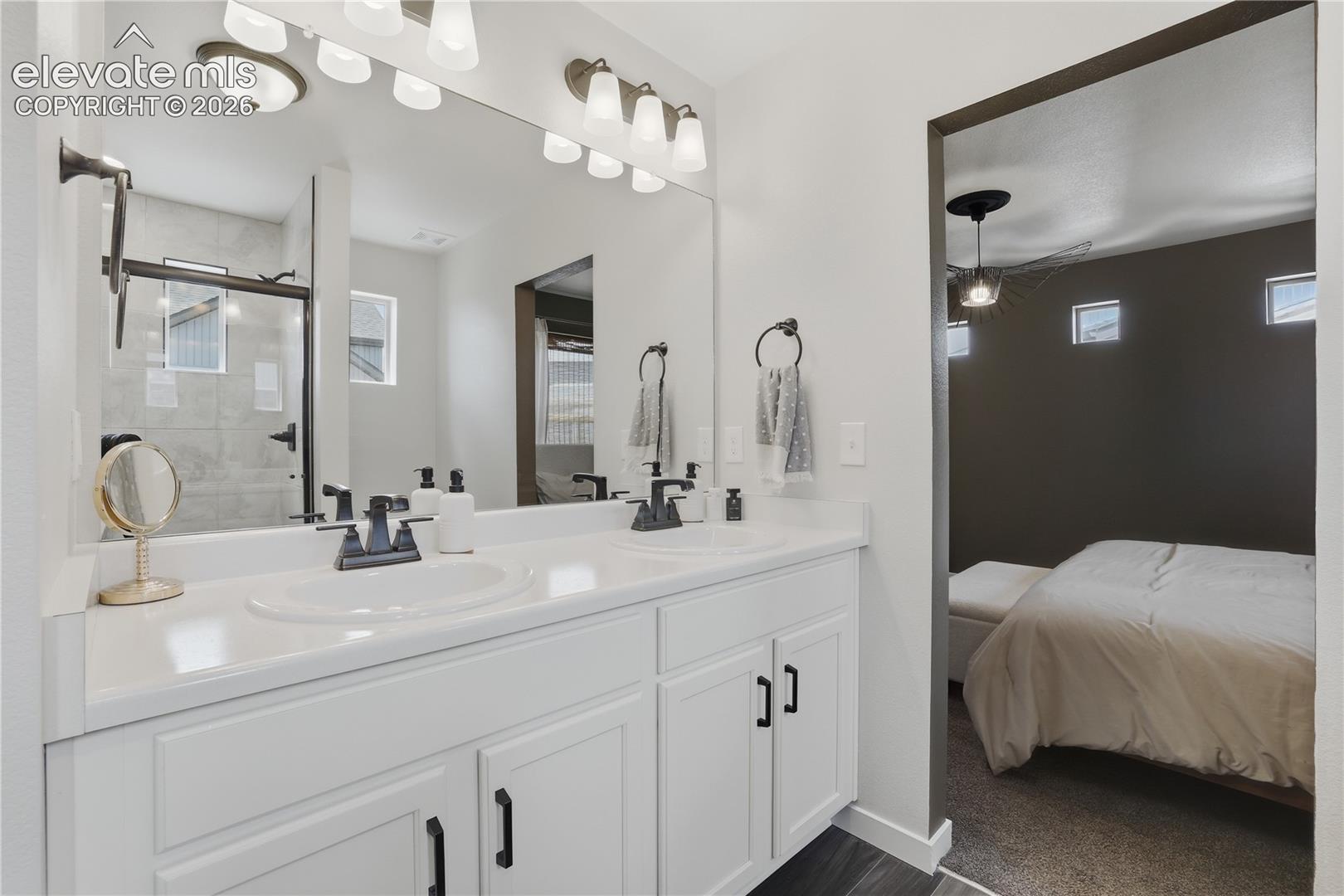 Dual vanity with white cabinetry and dark hardware