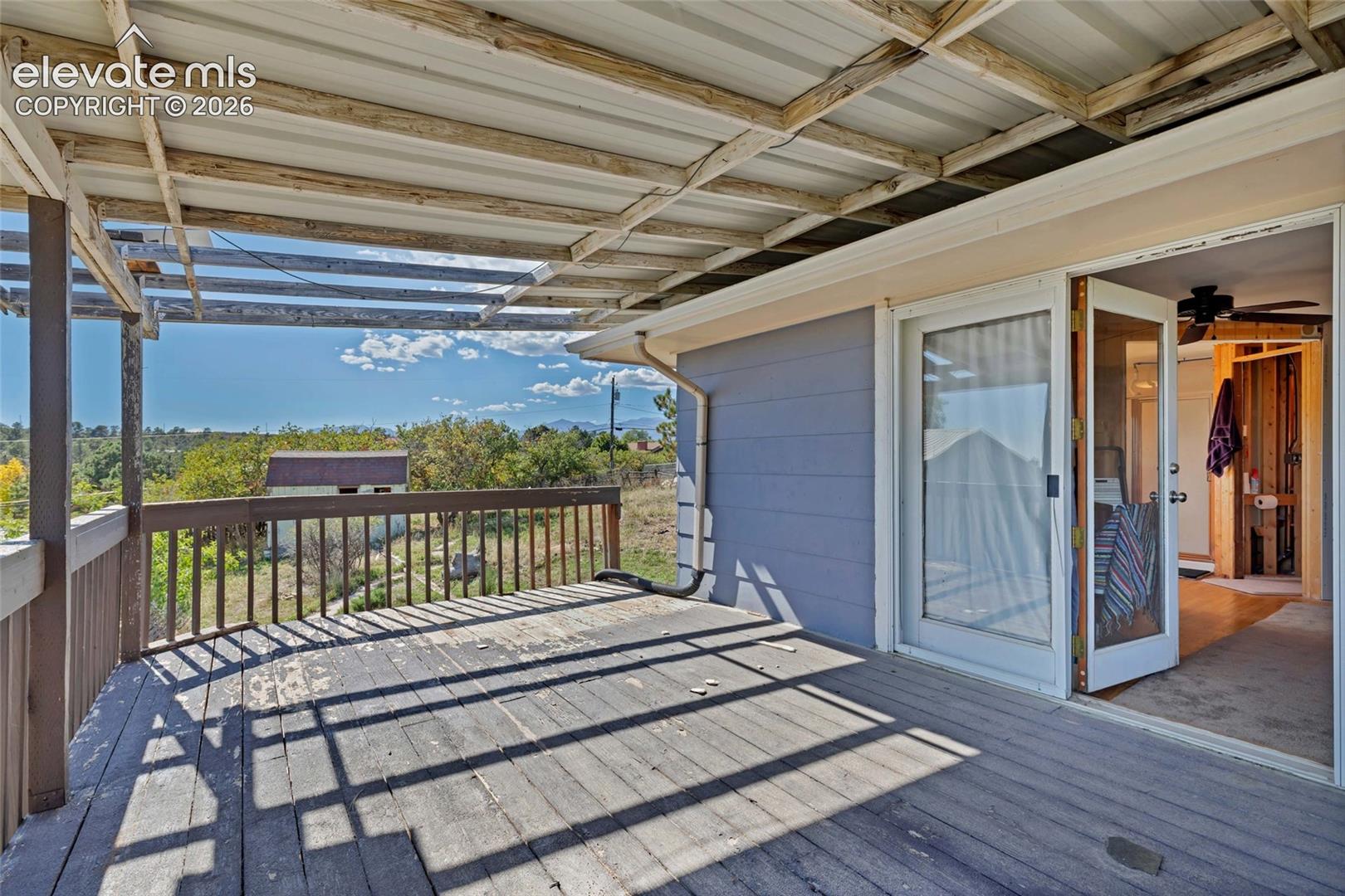 Covered outdoor deck with metal roof and wood railing