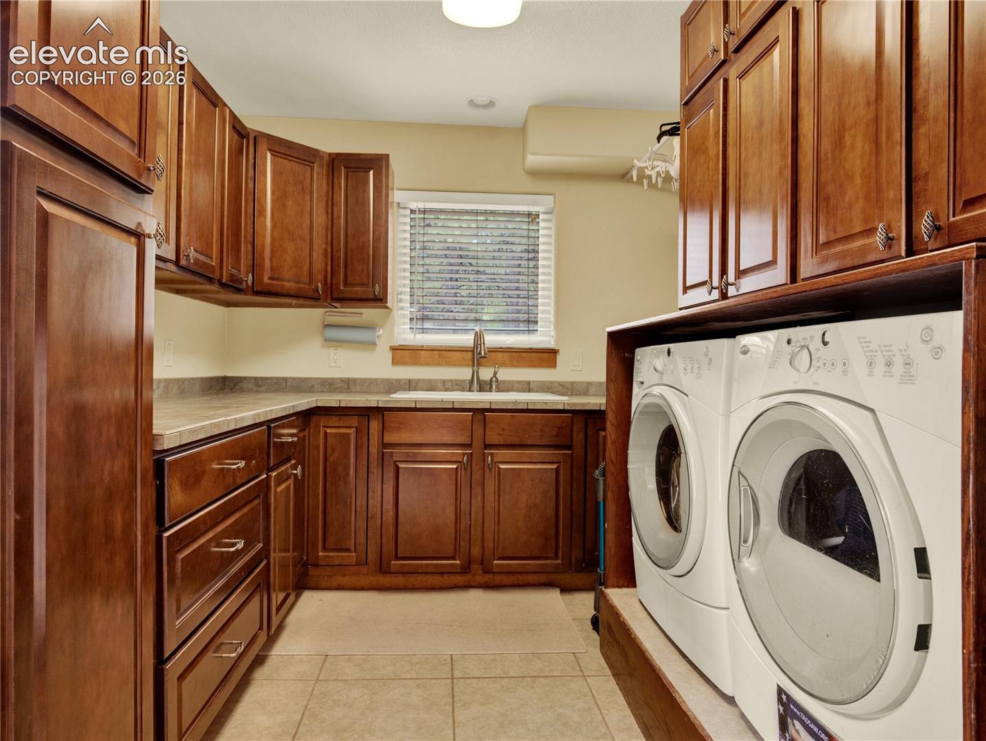 Large laundry room on the main level with a utility sink and a ample storage space