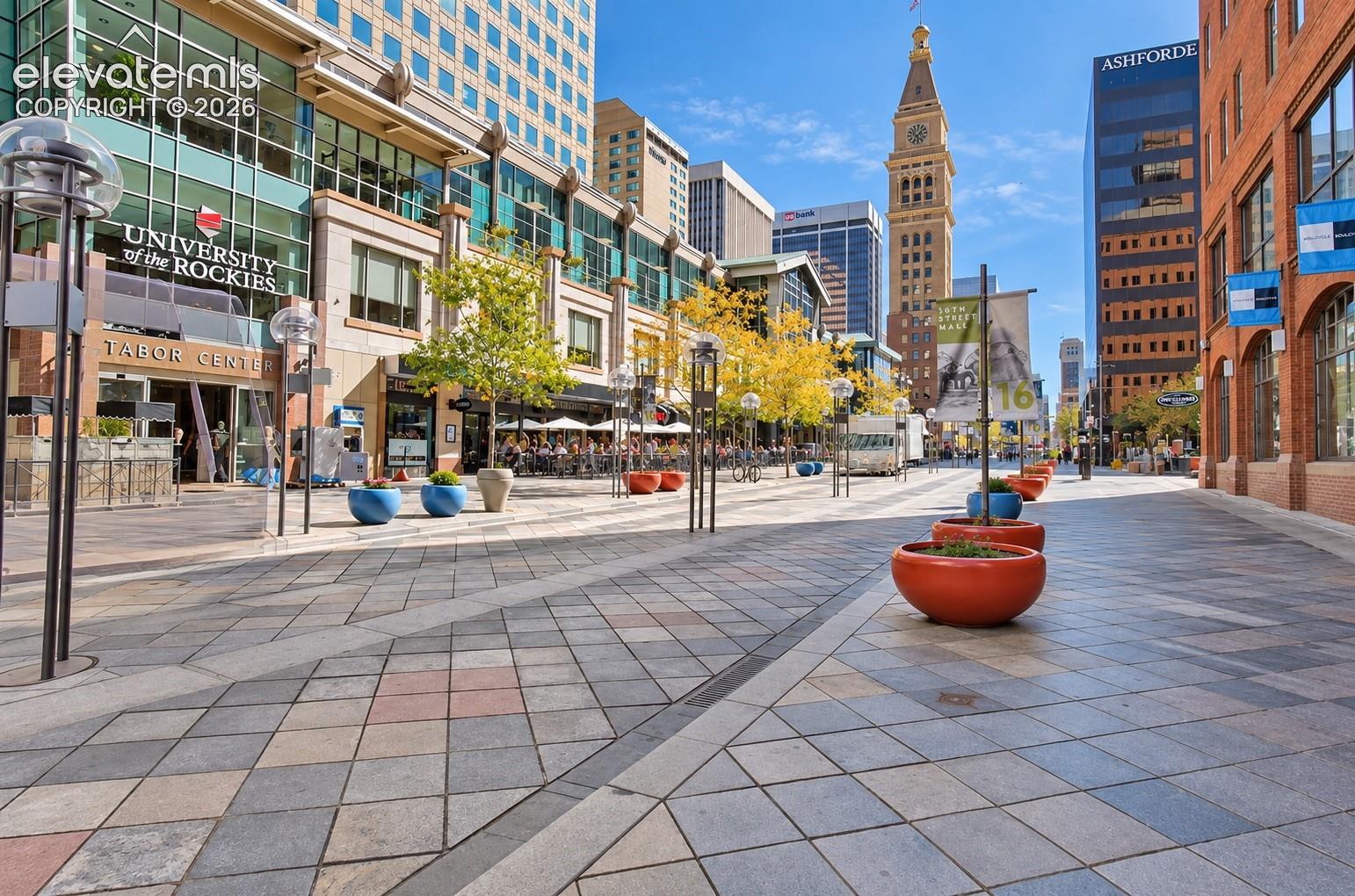 Paved pedestrian promenade featuring varied-tone pavers, mature trees, and street lamps