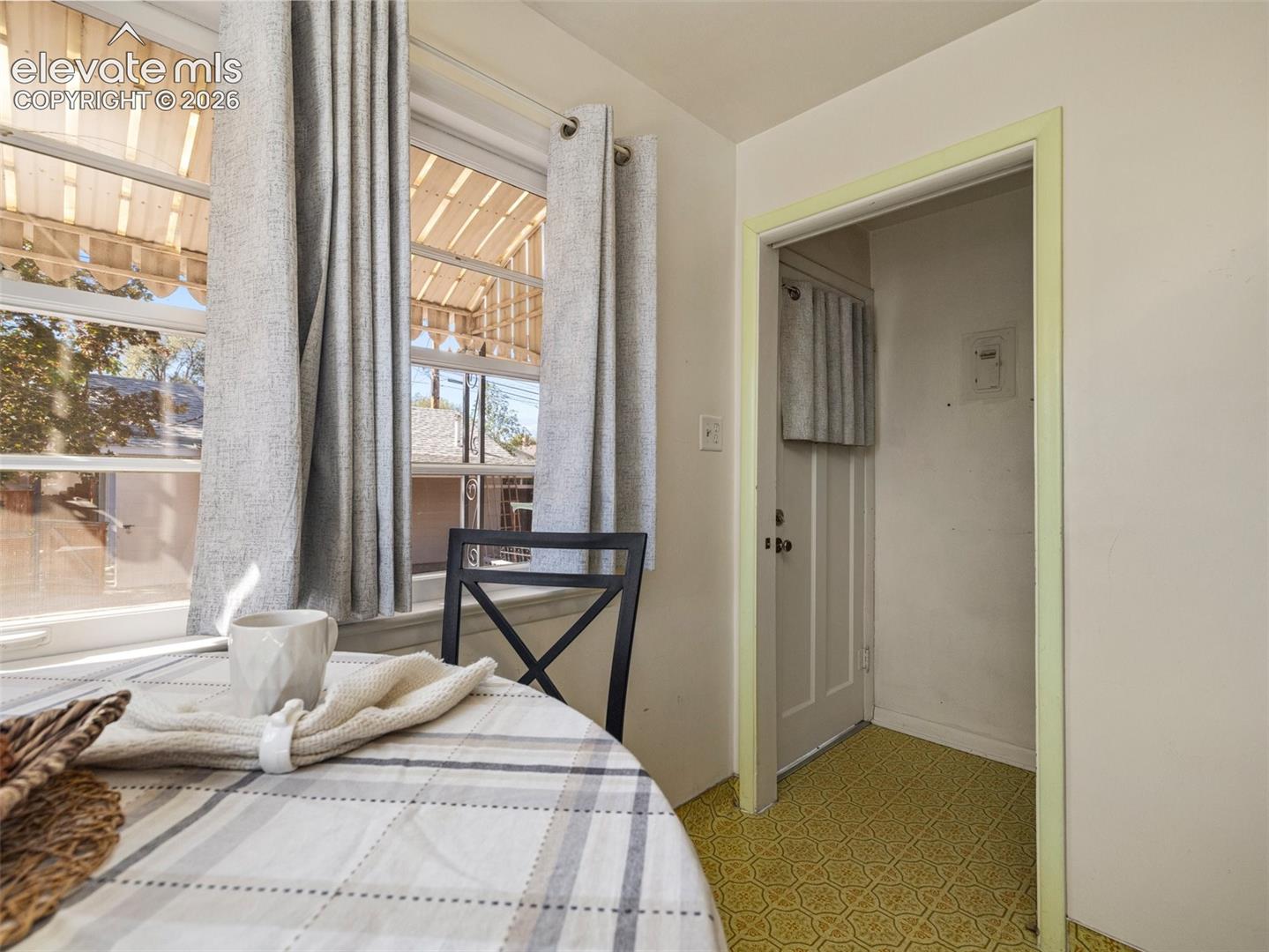 Multi-pane windows, patterned flooring, and a paneled interior door