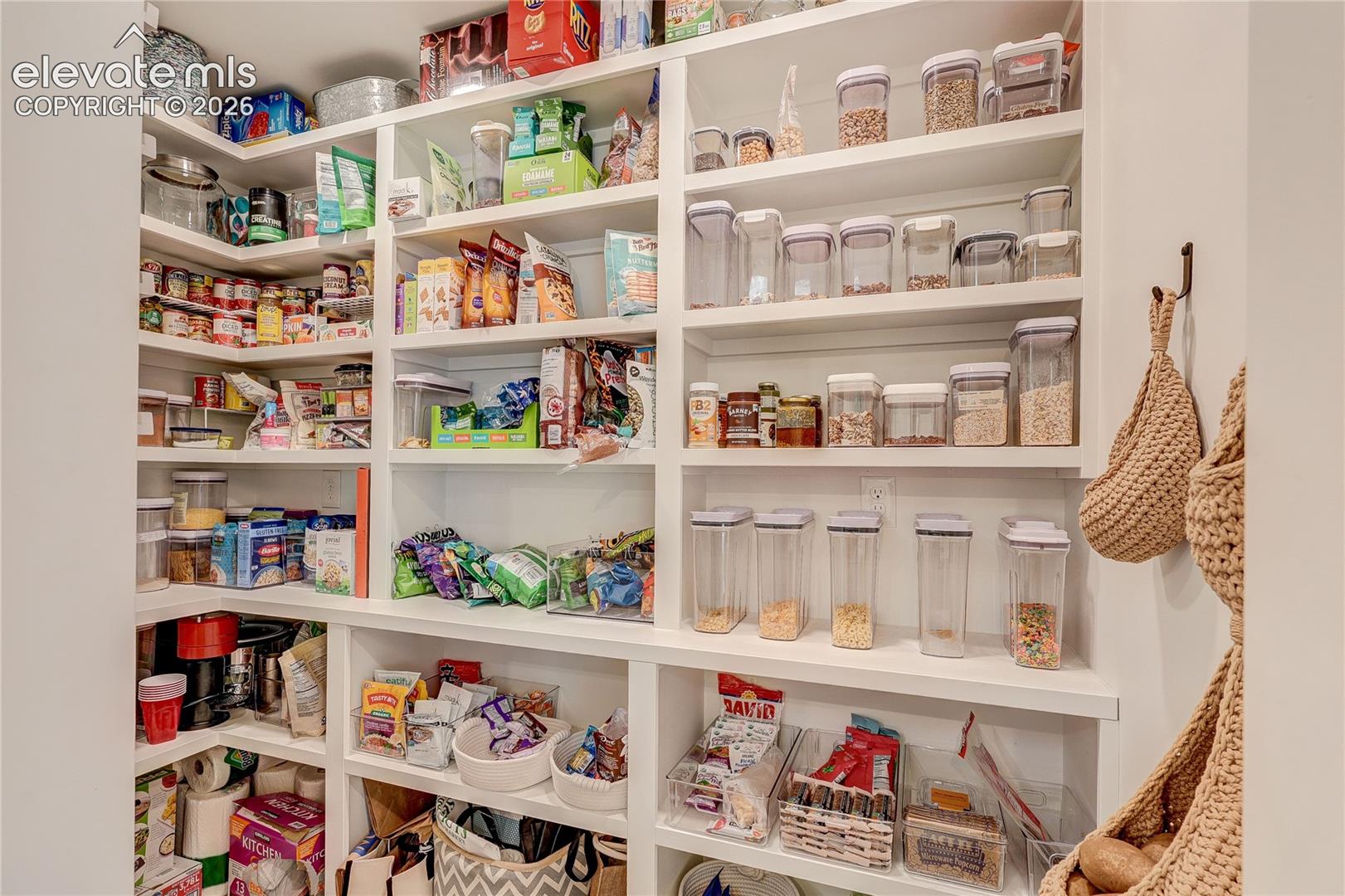 Expansive pantry featuring white built-in shelving, providing ample storage