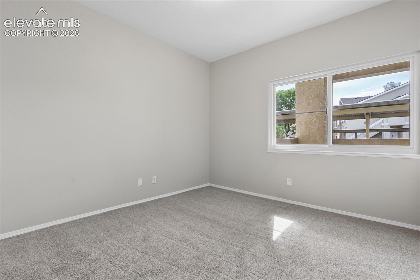 Neutral-toned walls complement the gray carpeting