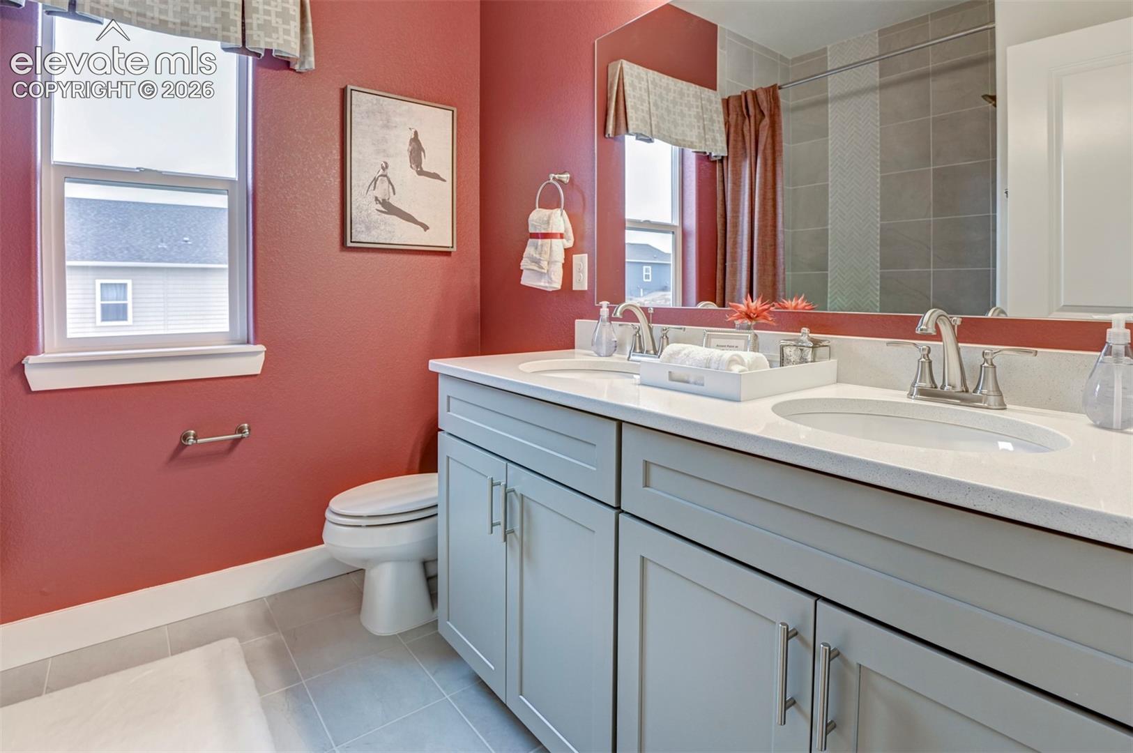 Dual vanity with light gray cabinetry, white countertops, and undermount sinks