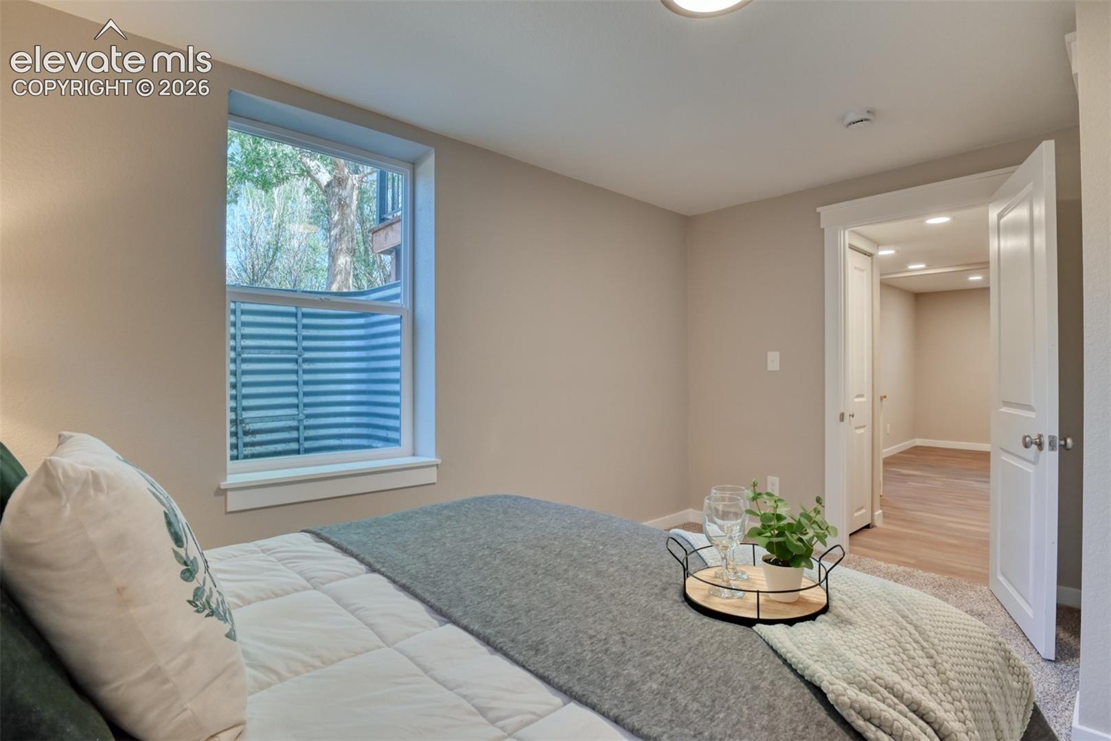 Recessed ceiling light, neutral wall color, white trim, and a window with an egress well