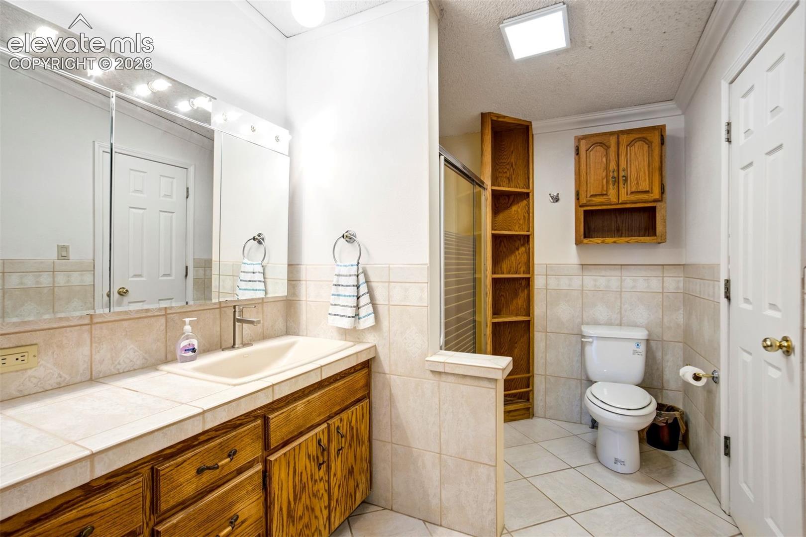 Large primary bath includes an oversized vanity, built-in cabinetry, and walk-in closet access.