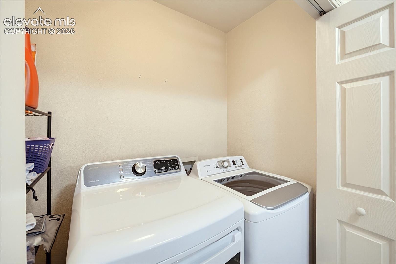 Dedicated laundry area featuring white appliances and a paneled door