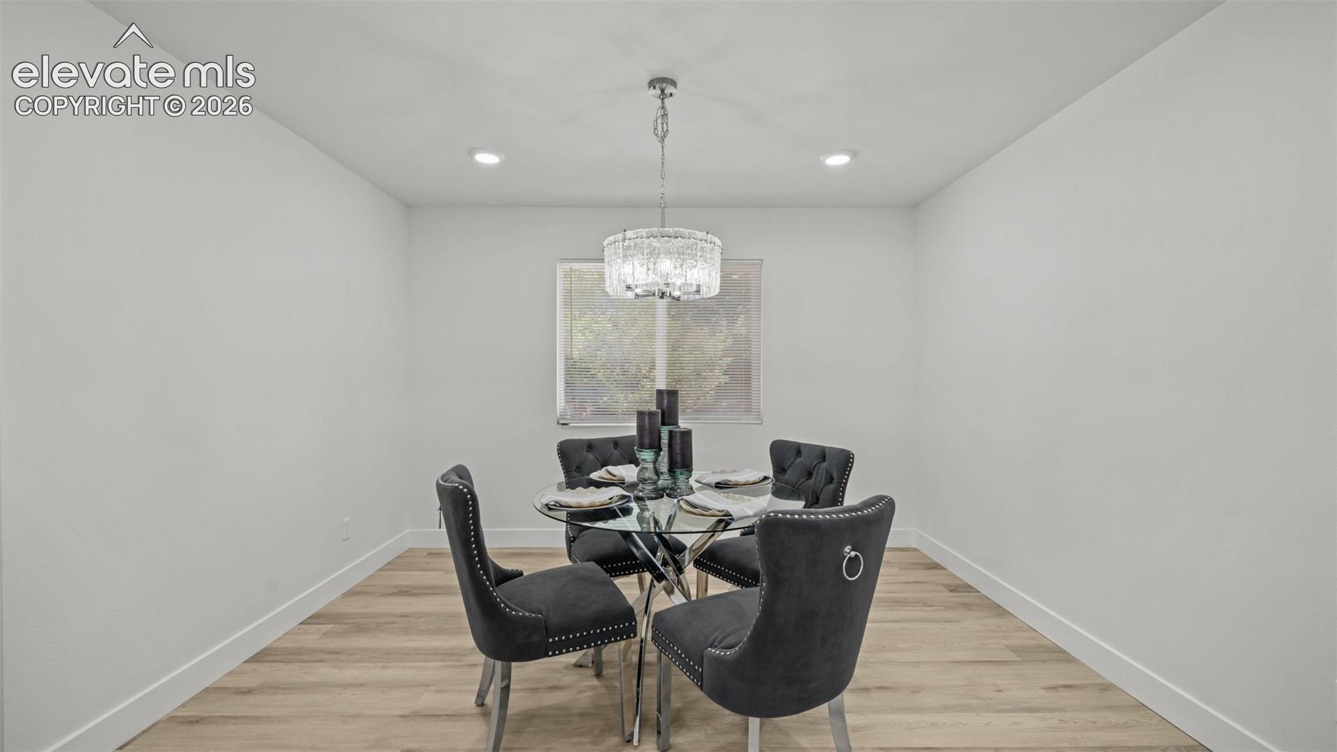 Recessed lighting, wood-finish flooring, and a window providing natural light