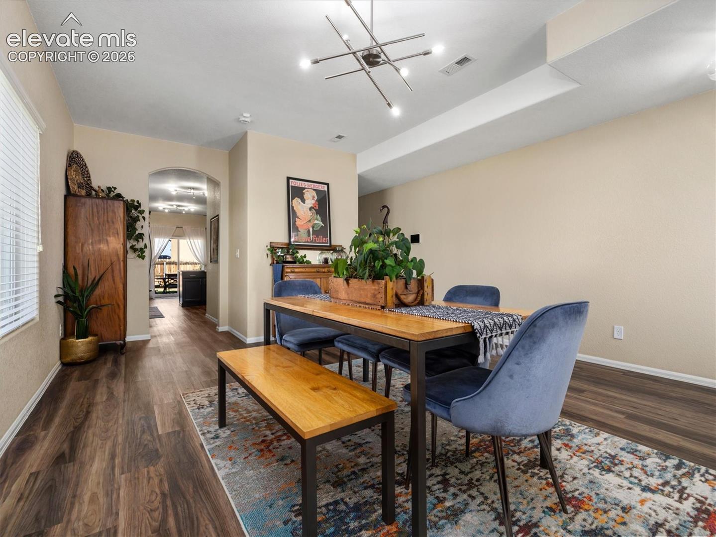 Recessed lighting, LVP wood-look flooring, and an arched doorway
