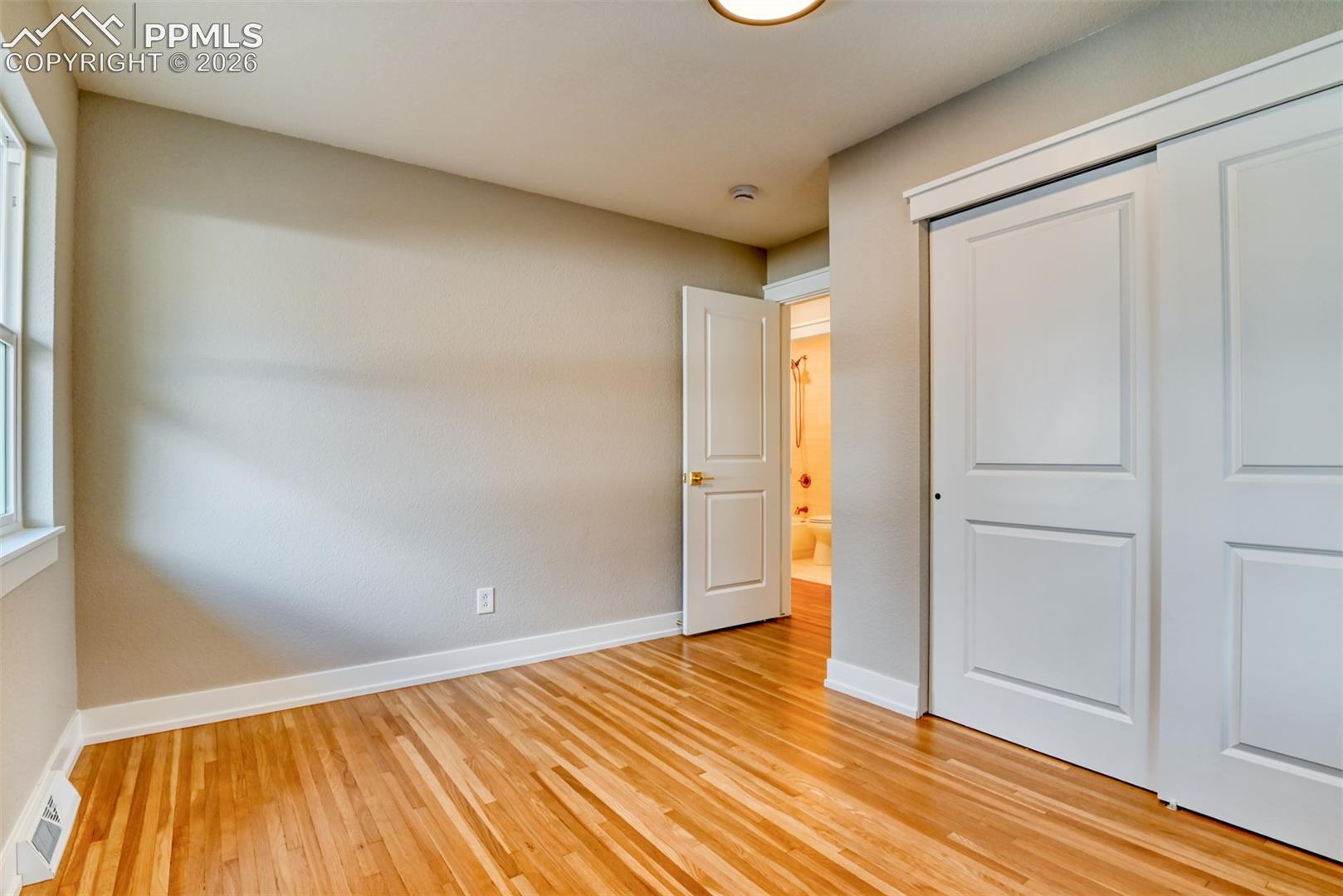 Unfurnished bedroom featuring light wood-style flooring and a closet