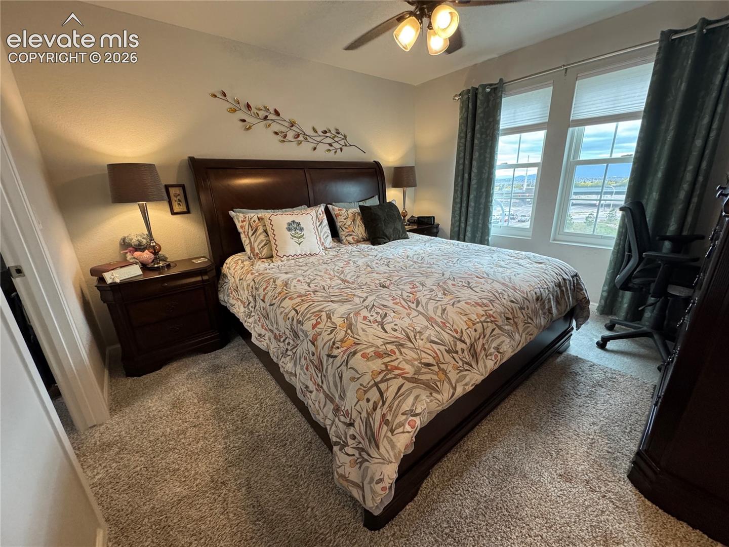 Neutral-toned room featuring plush wall-to-wall carpeting, dual-pane windows, and a ceiling-mounted light fixture with multi-directional bulbs