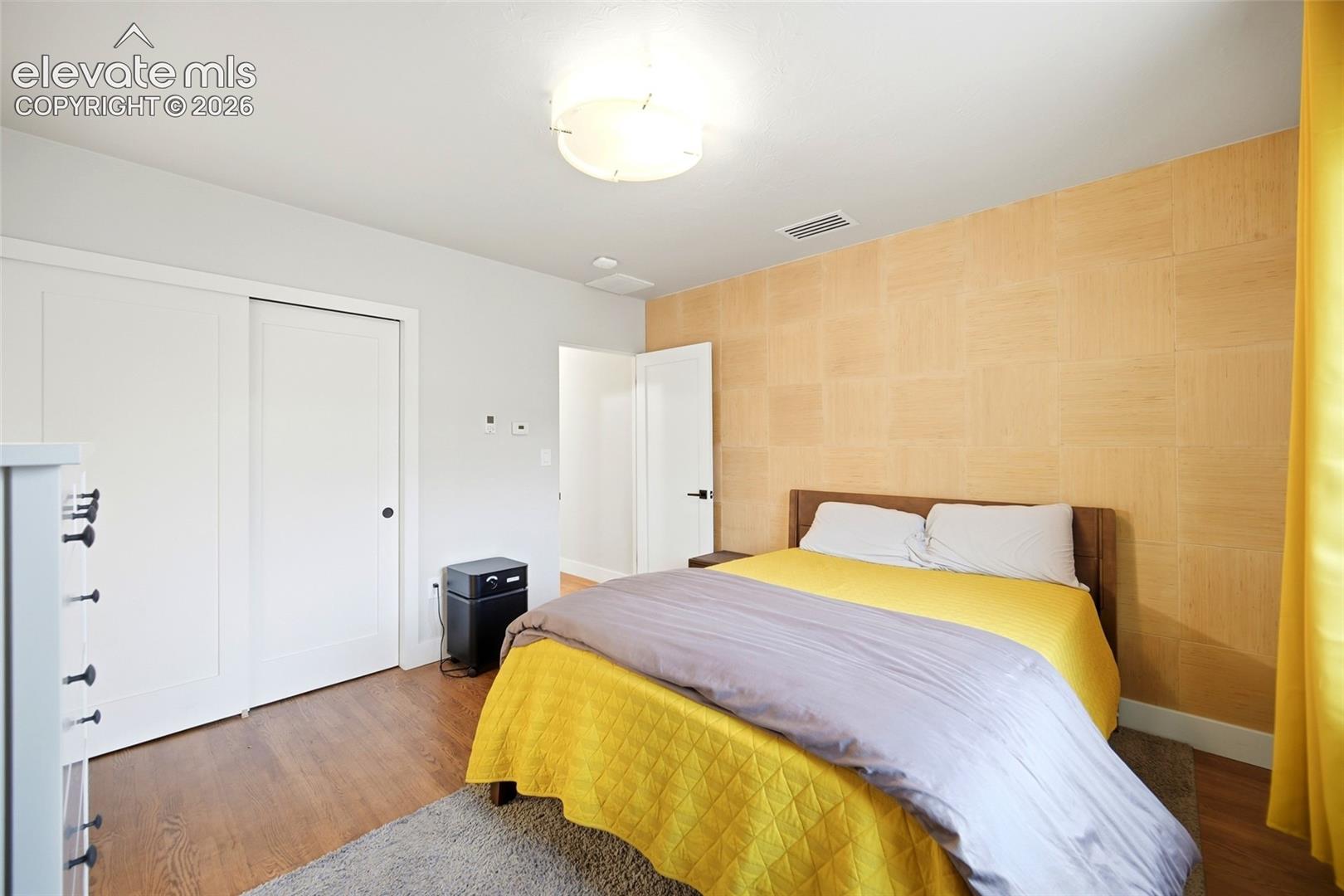 A gorgeous accent wall and a double closet highlight the primary bedroom. 