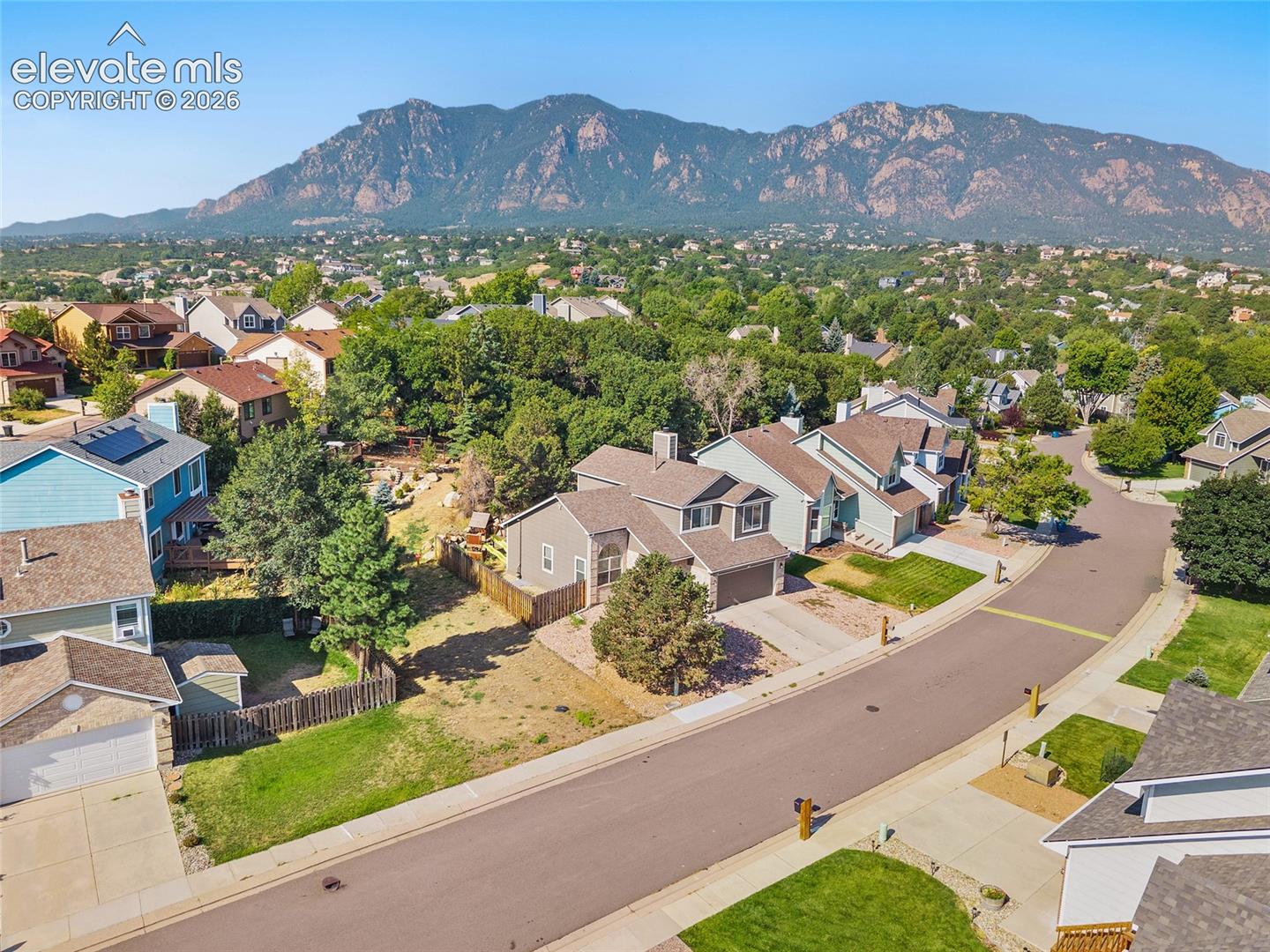 Mountain range backdrop with residential homes and mature trees