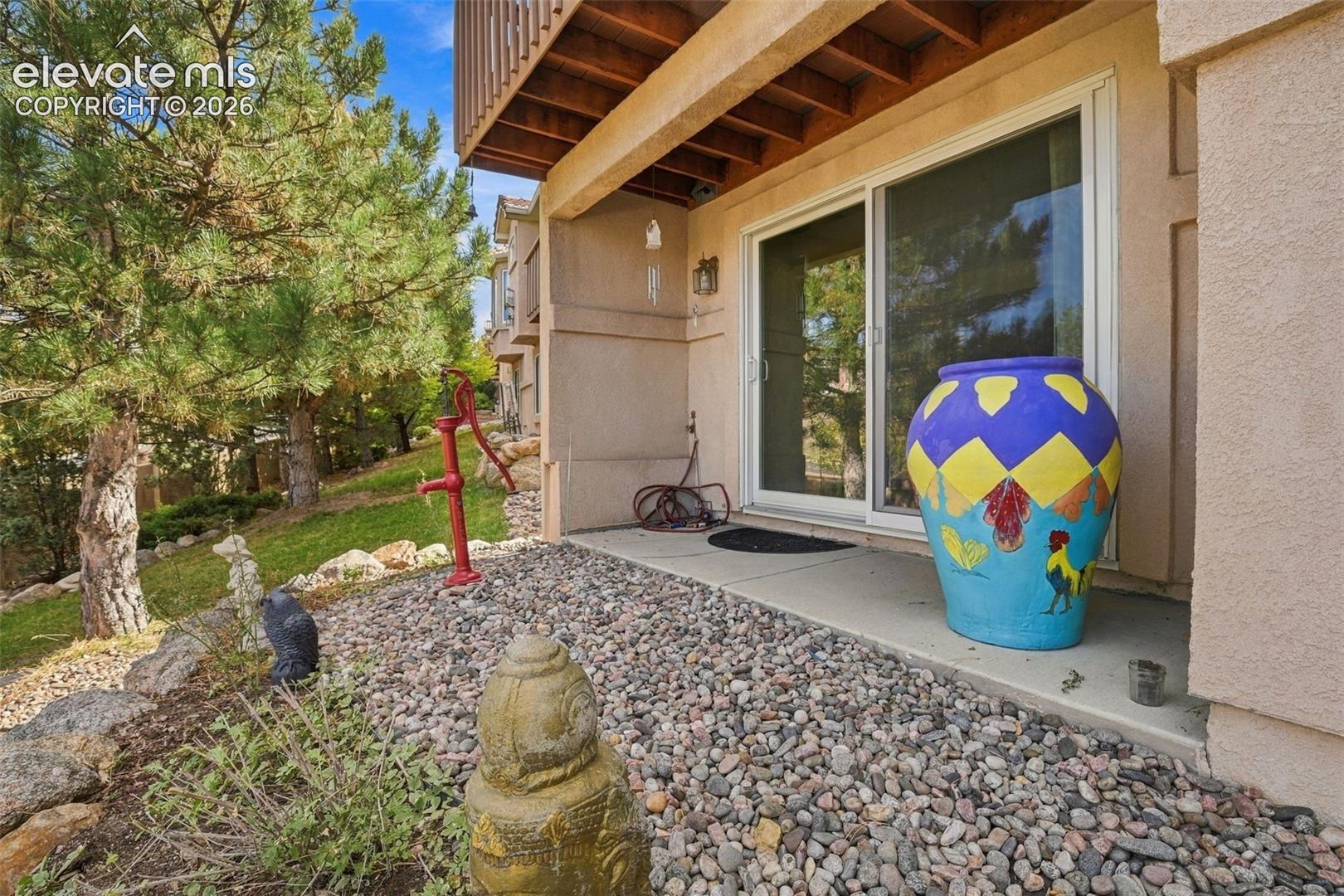 Patio space featuring concrete flooring, sliding glass door, and stone-accented exterior wall