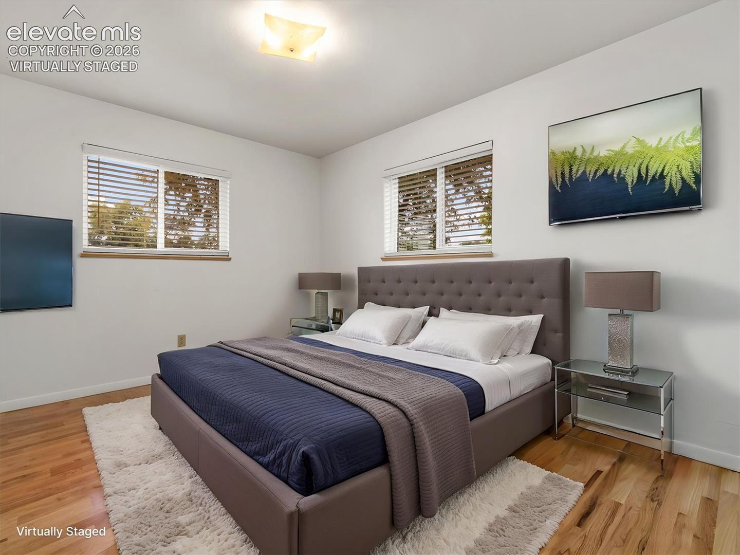 Virtually Staged, Hardwood flooring, two windows with blinds, recessed ceiling light, and a built-in upholstered headboard