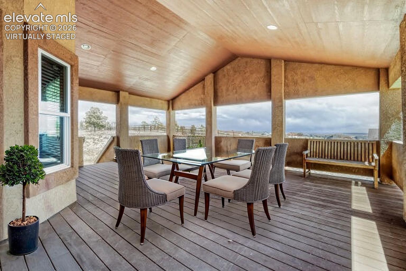 Virtually Staged -Covered outdoor balcony featuring a wood-finish floor, recessed lighting, and a textured ceiling