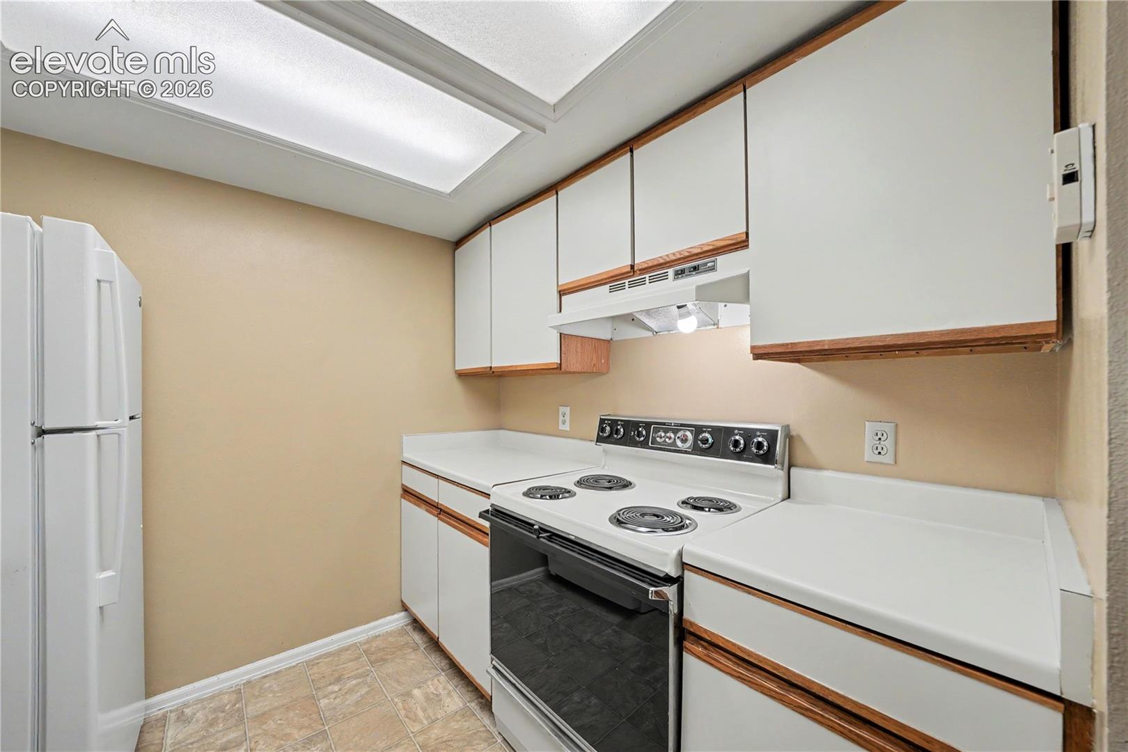 Kitchen with electric range and vent hood