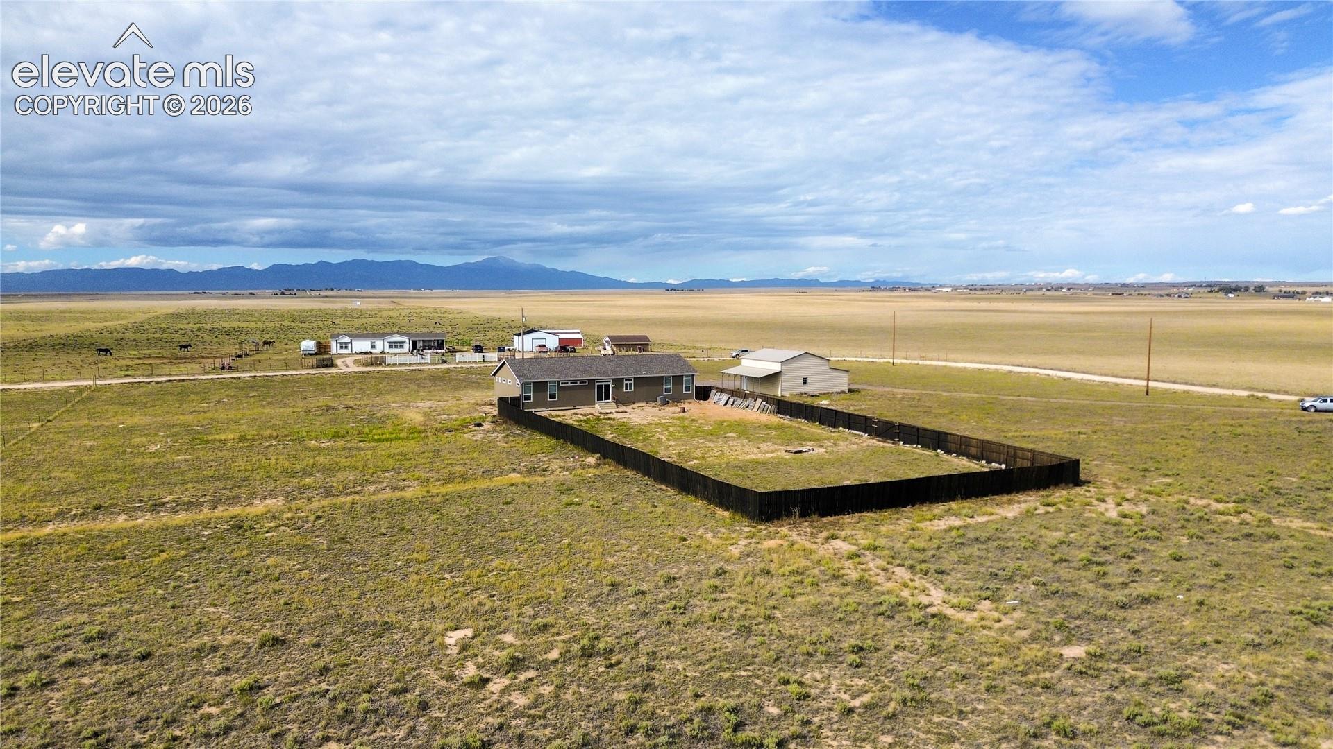 Expansive acreage featuring a detached structure, fenced yard, and mountain backdrop