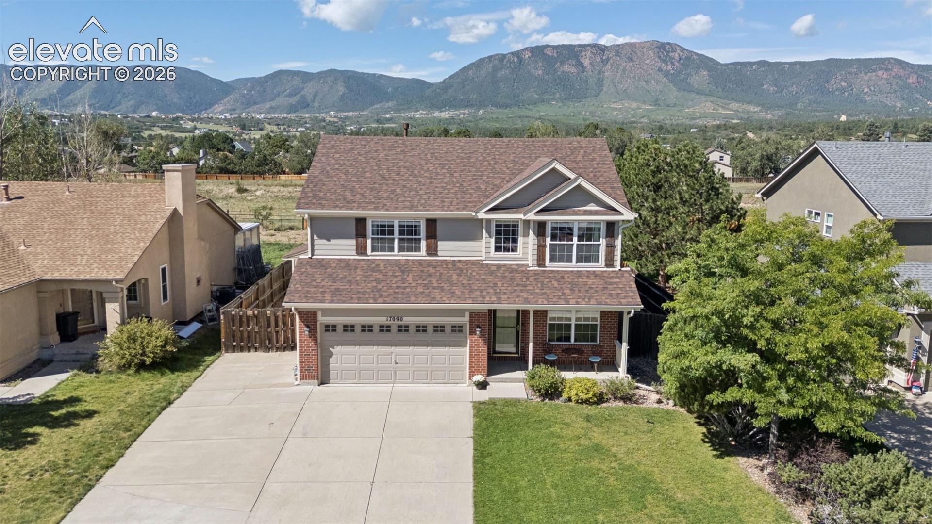 Two-story residence with a two-car garage, brick and siding exterior, and a peaked roof