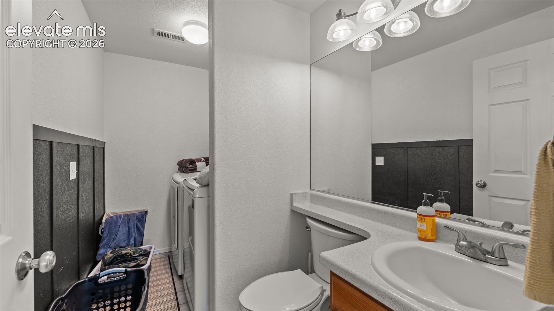 Bathroom with a single vanity, integrated sink, and overhead lighting