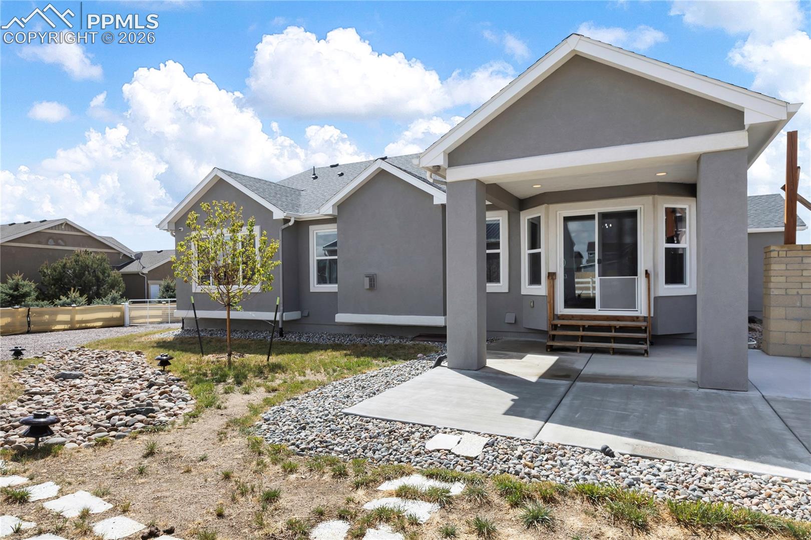 Rear exterior showcasing a covered patio with concrete flooring