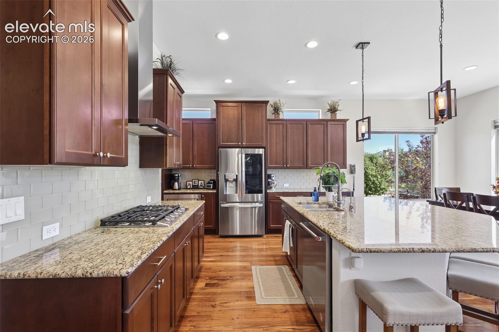 Kitchen featuring wood-finish flooring, recessed lighting, and a kitchen island with pendant lighting