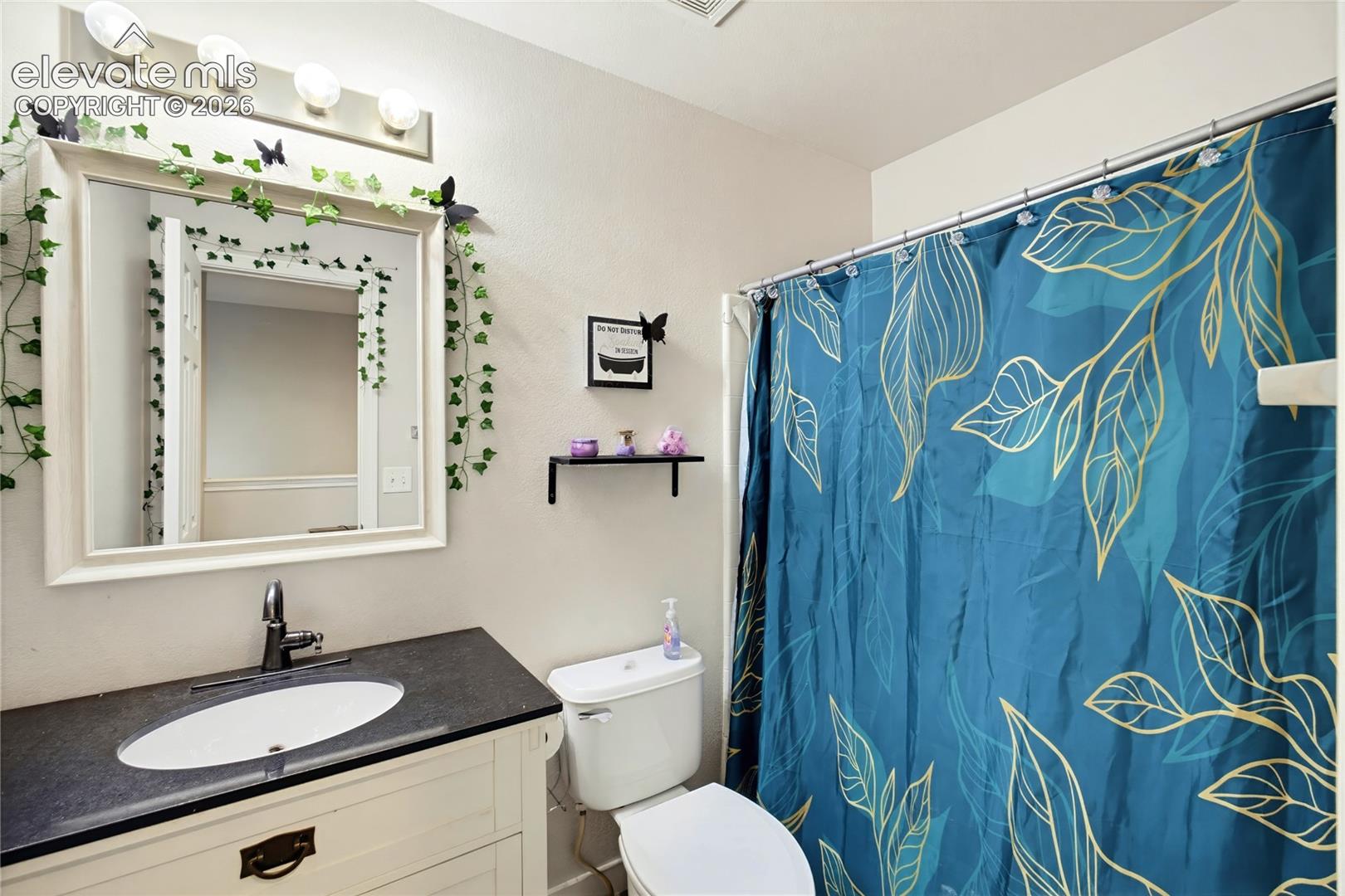 Vanity with integrated sink, dark countertop, and matte black faucet