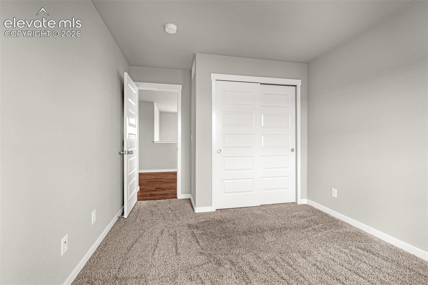 Neutral-toned walls complement the plush carpet flooring