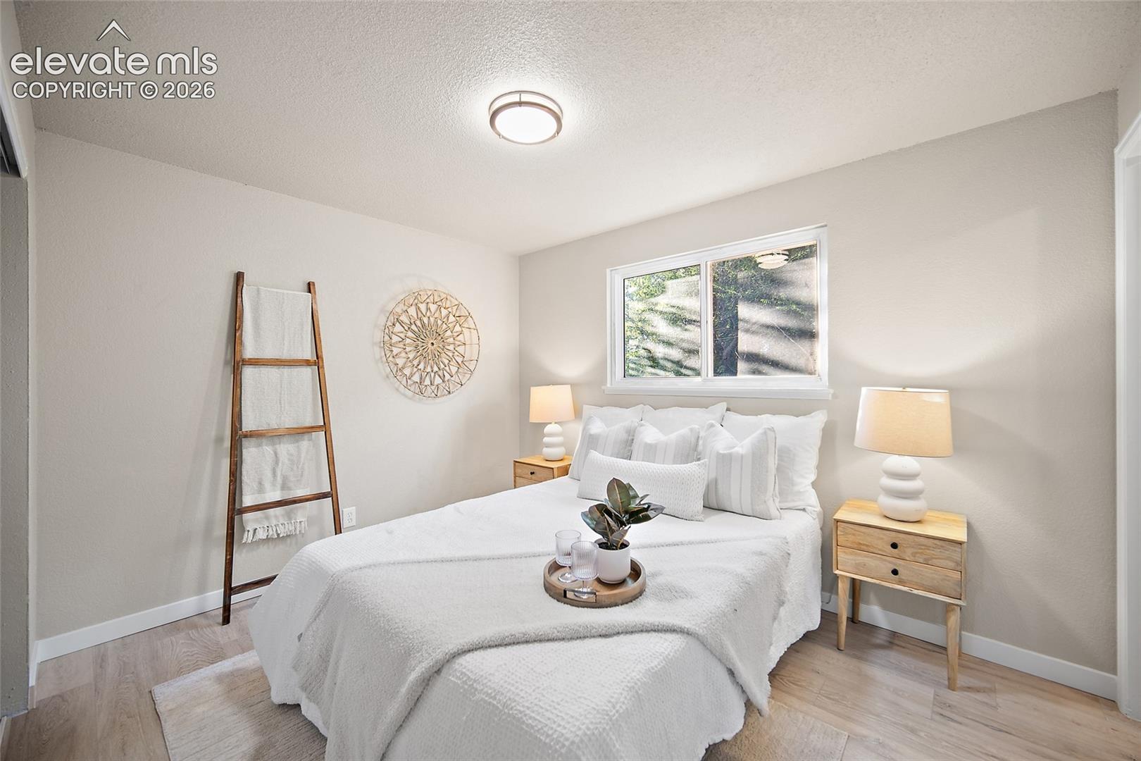 Recessed ceiling light, light wood-finish flooring, white trim, and a window with natural light