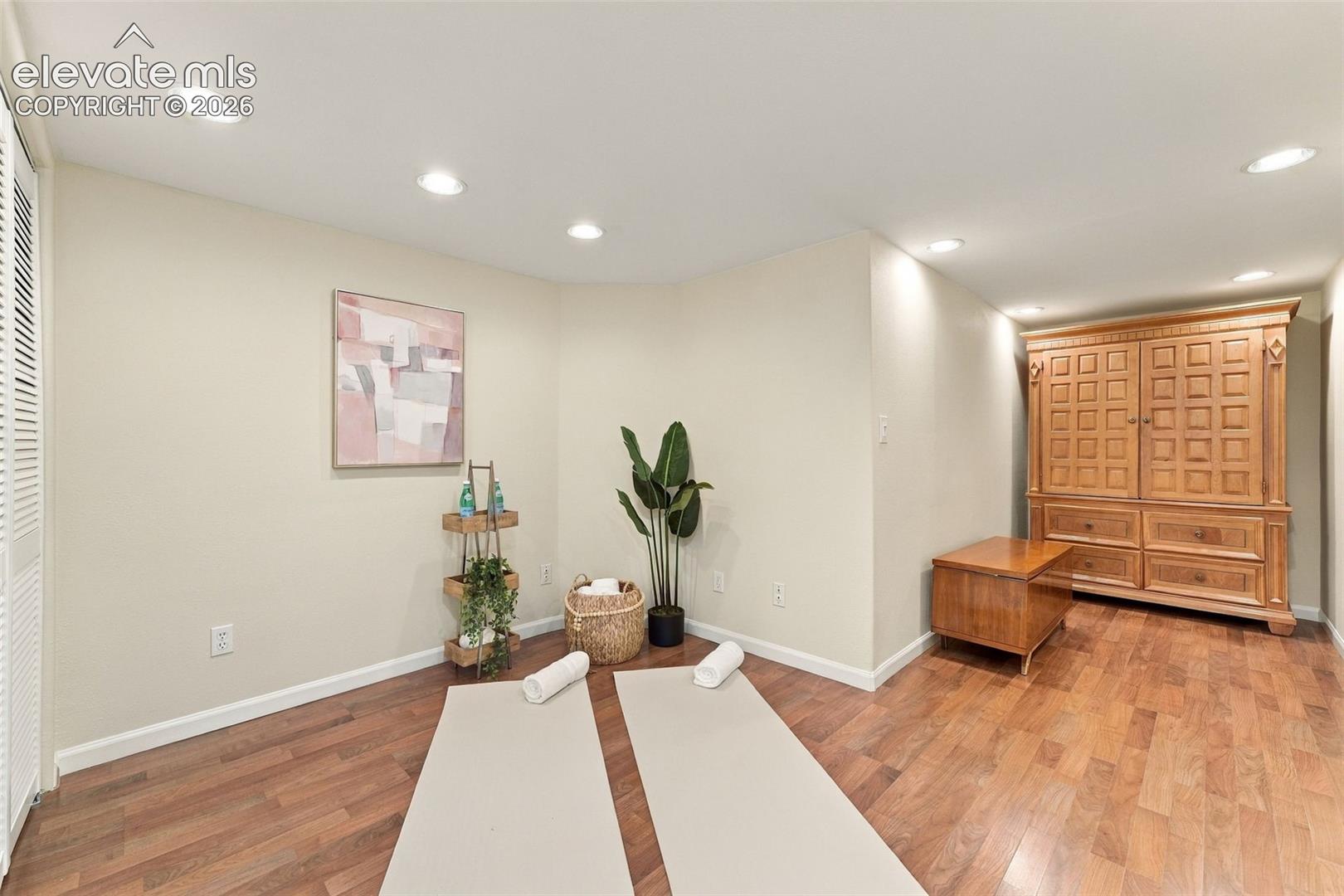Room featuring wood-finish flooring, recessed lighting, and neutral wall paint