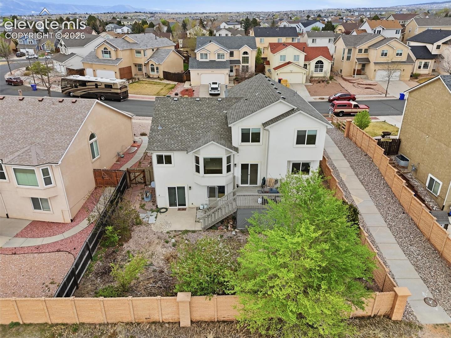 Two-story residence featuring a private backyard, an upper-level deck, and bay windows