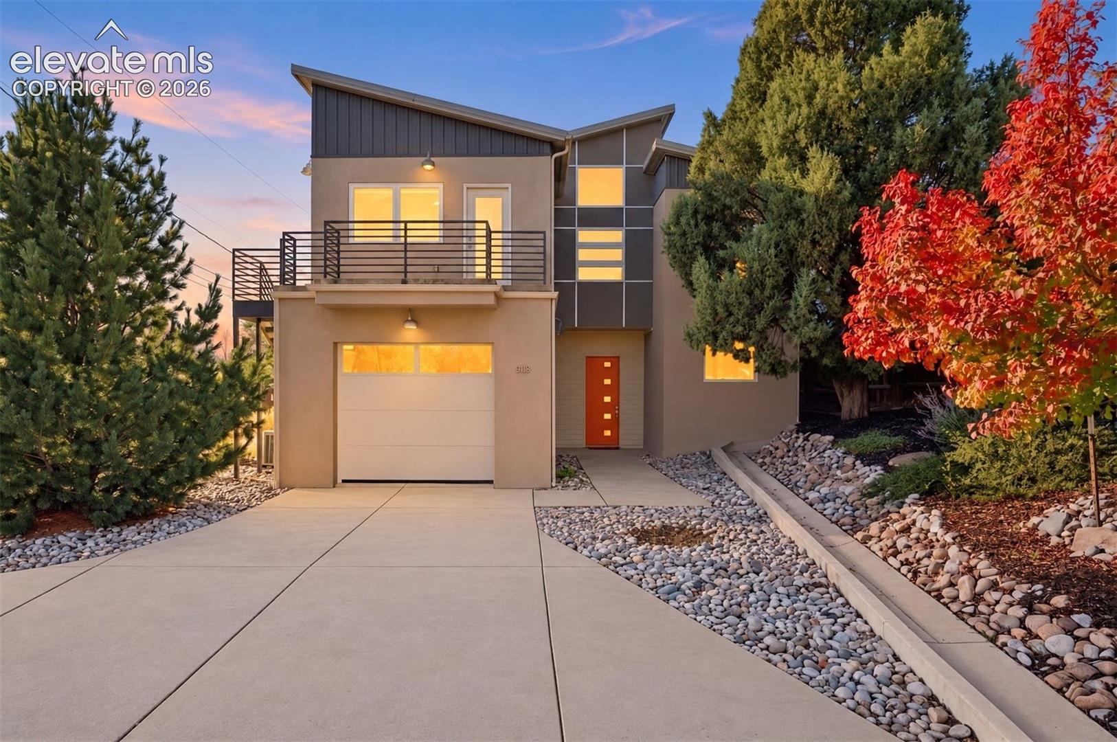A true one-of-one creation, this elegant, architect-designed attached single-family home (no HOA) offers four spacious bedrooms, polished concrete floors, an upper-level balcony deck with separate street-level-accessed entrance, & 2 enclosed patios. Constructed of high-efficiency Insulated Concrete Forms (ICF), this is minutes from downtown via the Pike's Peak Greenway and close to the Mesa Valley Trail which connects all the way to Garden of the Gods. Ten-foot ceilings on the main level are accentuated by eight-foot doors. The generous living room offers incredible flexibility, operating as a hub for daily life with a gas fireplace, and a walkout to the enclosed east side patio. The modern, slab-faced cabinets in the kitchen offer an incredible amount of storage and are complimented by extensive quartzite counters. The gas range is ducted, and the wall oven and microwave add a sophisticated element to any evening's preparation. Out the back of the main level is another discreet patio that features a gas line connection. Two single-bay garages are each more than 22' deep with the main garage featuring a dramatic 9' door. Upstairs, brand-new carpet captures the sun-filled vision with a standout family room. This incredible space is perfect for media or hang time, with its own wet bar and vaulted ceilings. Alongside this room is a cavernous bedroom that doubles as an office. With a built-in armoire for storage, vaulted ceilings, and a separate entrance, this is perfect for small business owners or guest access. Two additional bedrooms share a full bath, and the laundry facilities are at the end of the hallway. The primary suite is set apart from the other bedrooms and has mountain views through up-down blinds, an 80 square foot walk-in closet with built-ins and its own armoire. Heated floor tile is found in the bath and a well-appointed shower. A new metal roof (November 2026) & 3-zone heating system bring life together with timeless intentionality.