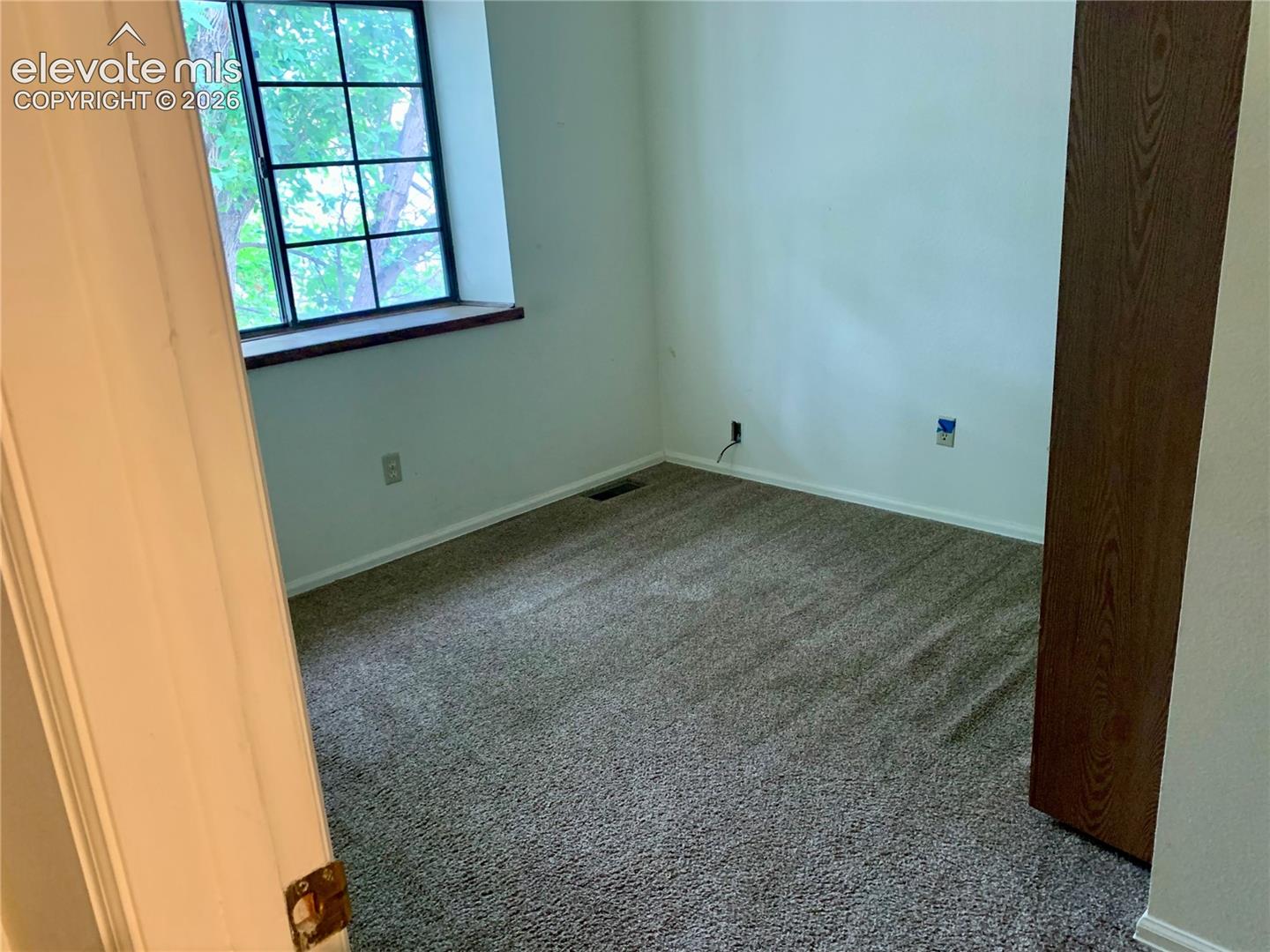 Bedroom Carpeted flooring, white walls, and a window with dark framing