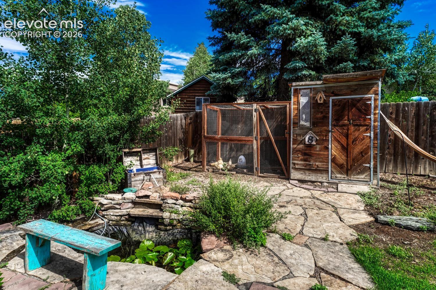 Serene water feature surrounded by a flagstone patio, and a chicken coop to raise your own chickens (chickens not included).