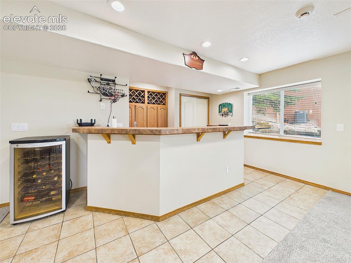 Entertainer’s wet bar with wraparound counter seating and built-in wine storage.