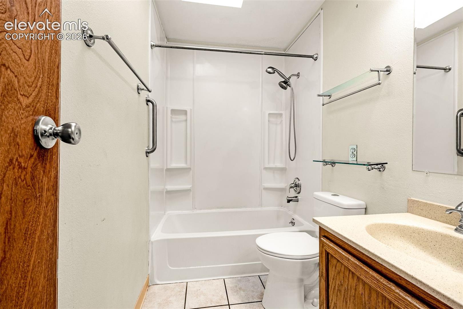 Full bathroom with tub/shower combo, skylight and tile flooring