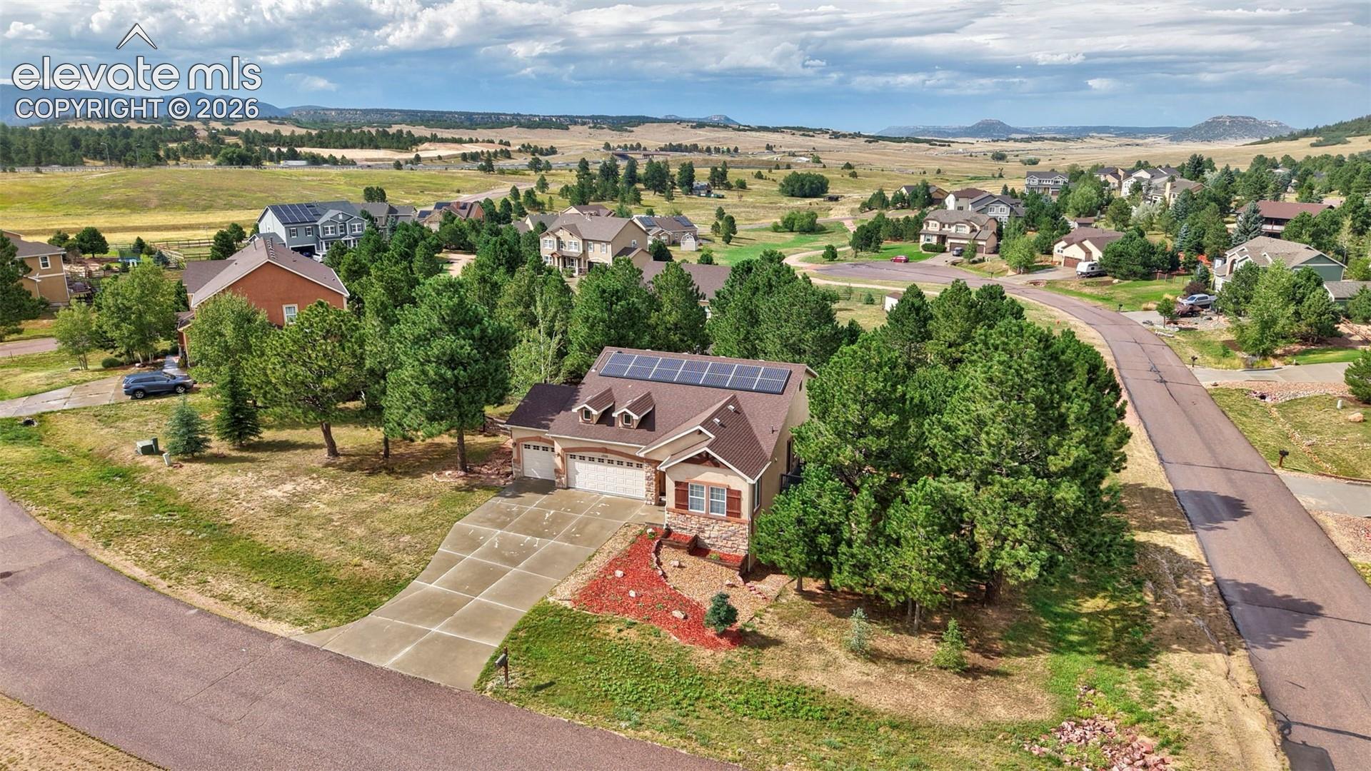 Residential property featuring a concrete driveway, attached garage, and solar panels