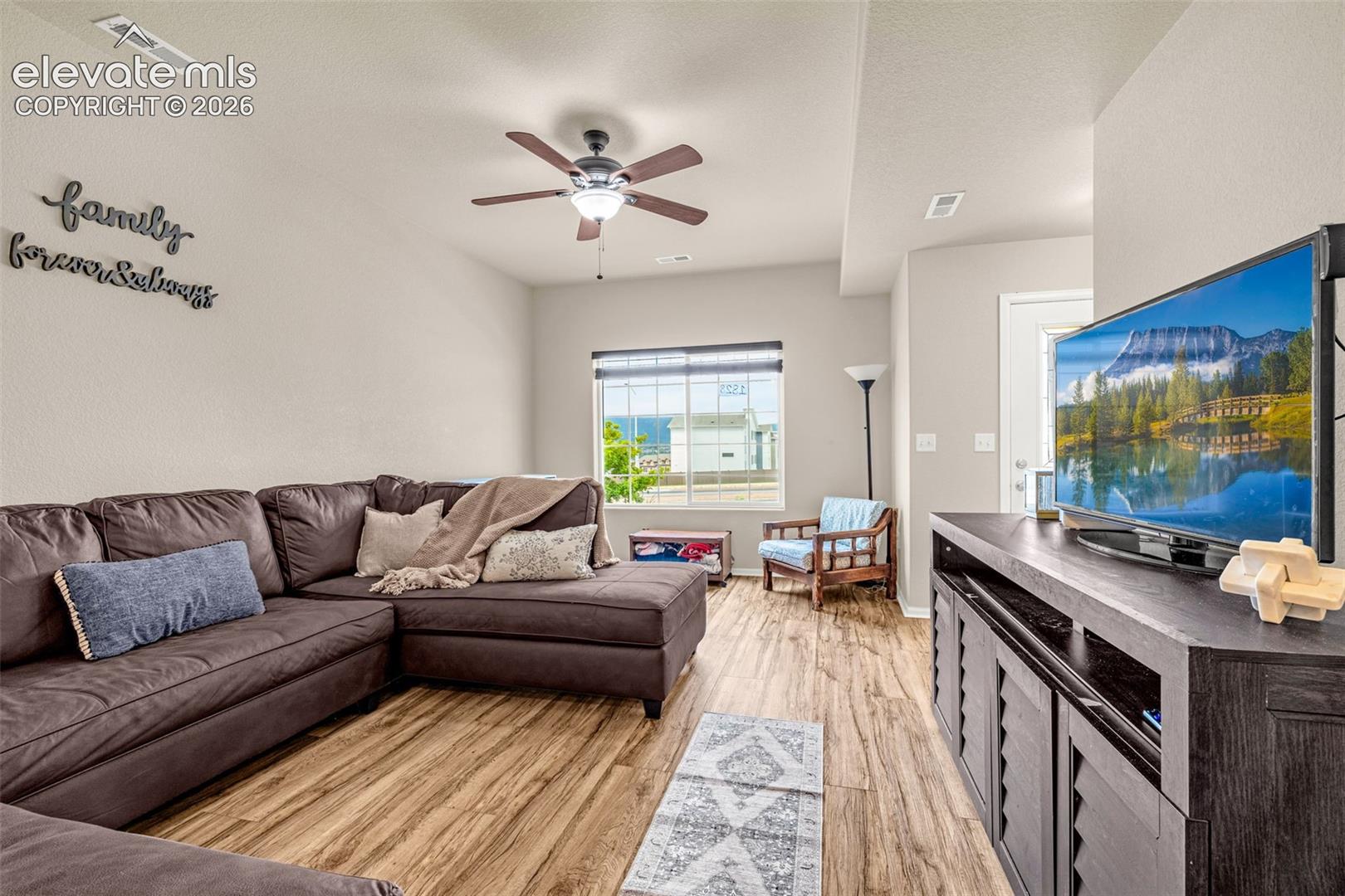 Wood-finish flooring throughout, complemented by a ceiling fan with integrated lighting