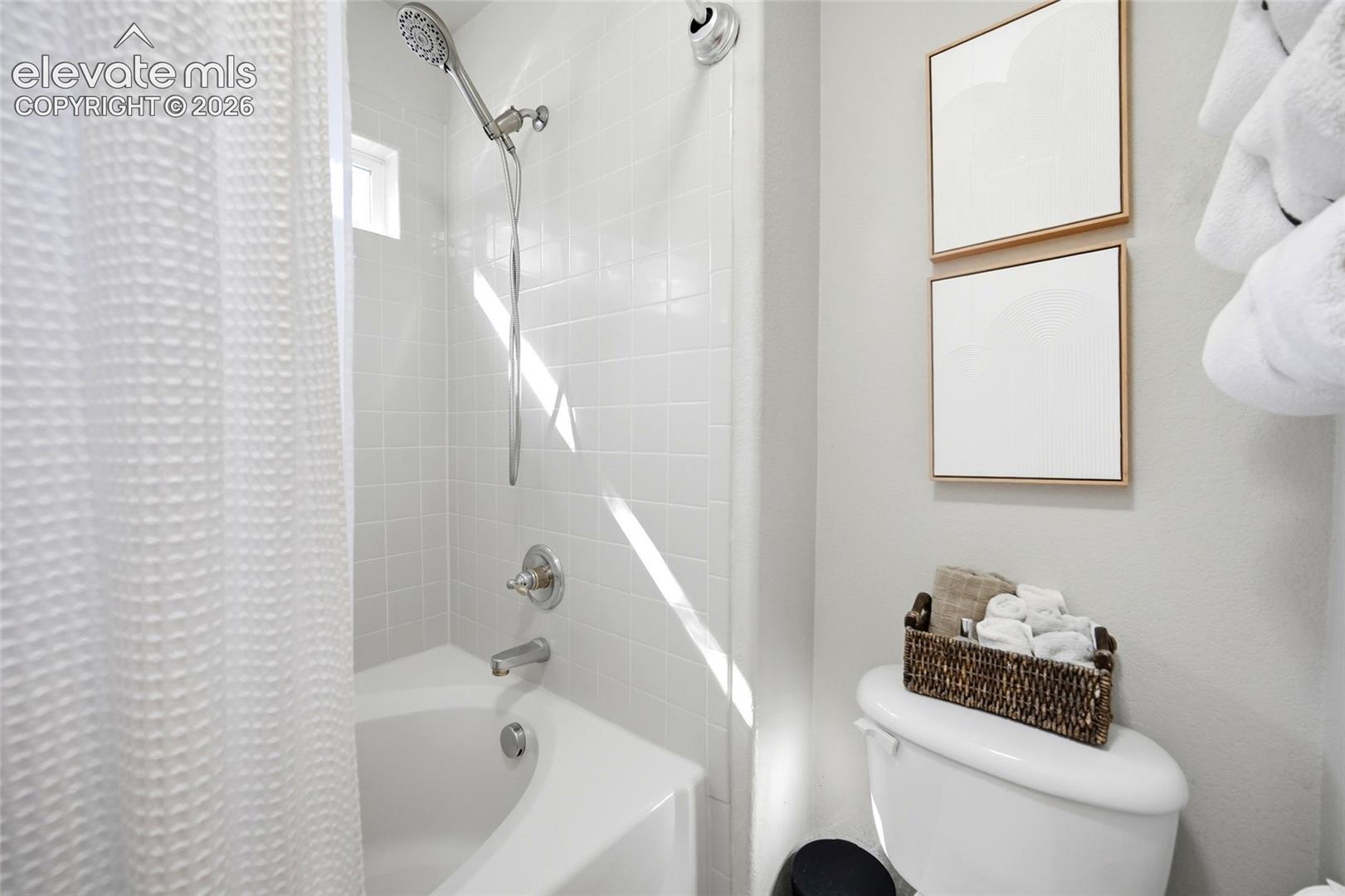 White subway tile shower surround with a built-in tub, chrome fixtures, and a showerhead with a detachable wand