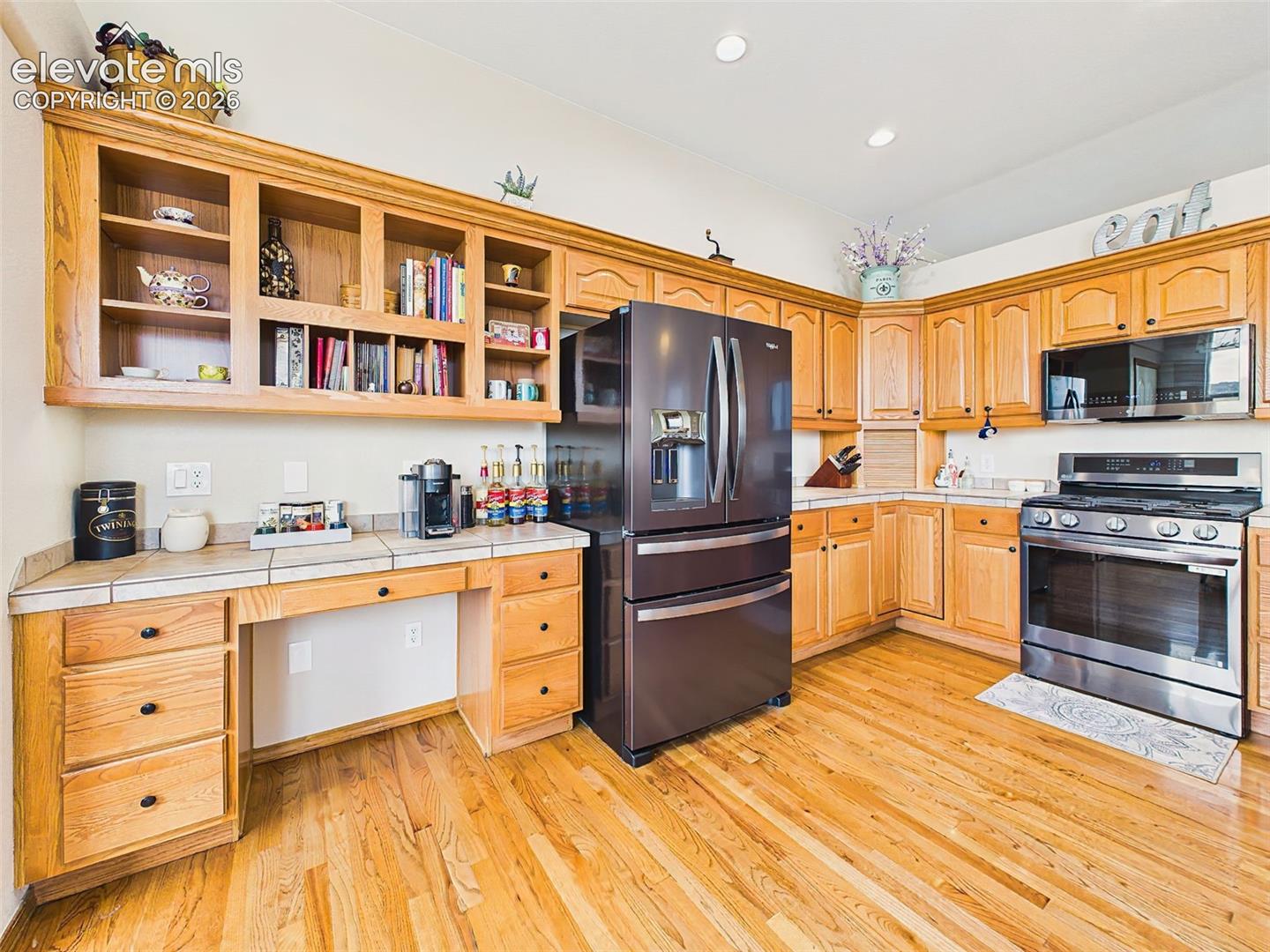 Bright kitchen with abundant cabinetry, updated appliances, and a convenient built-in workspace or coffee station.